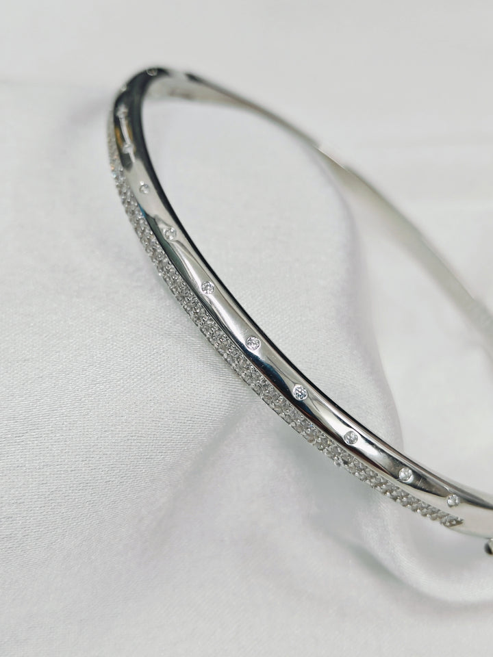 Silver bracelet with small stones on a light gray background