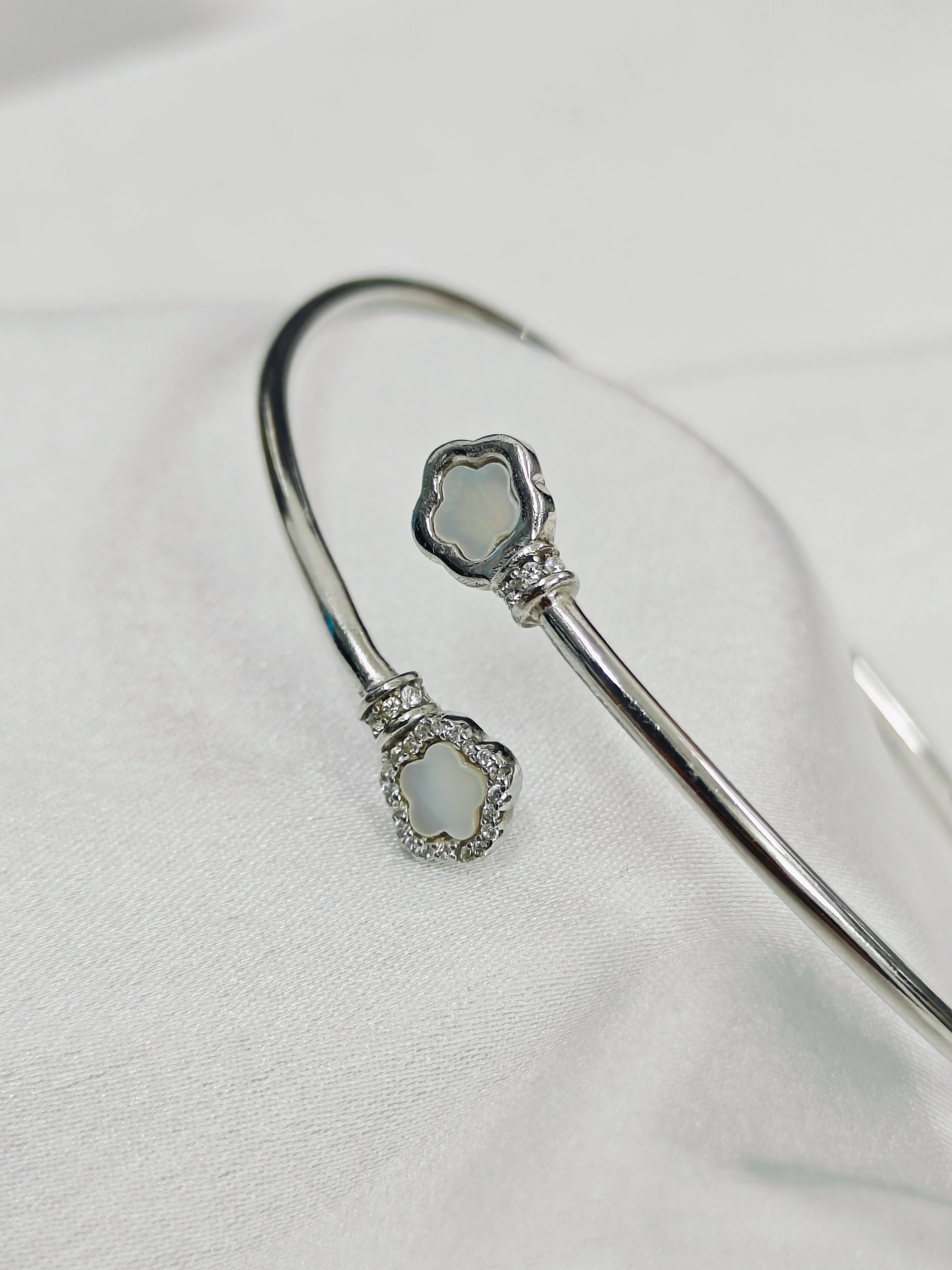 Silver bracelet with decorative elements on a light gray background