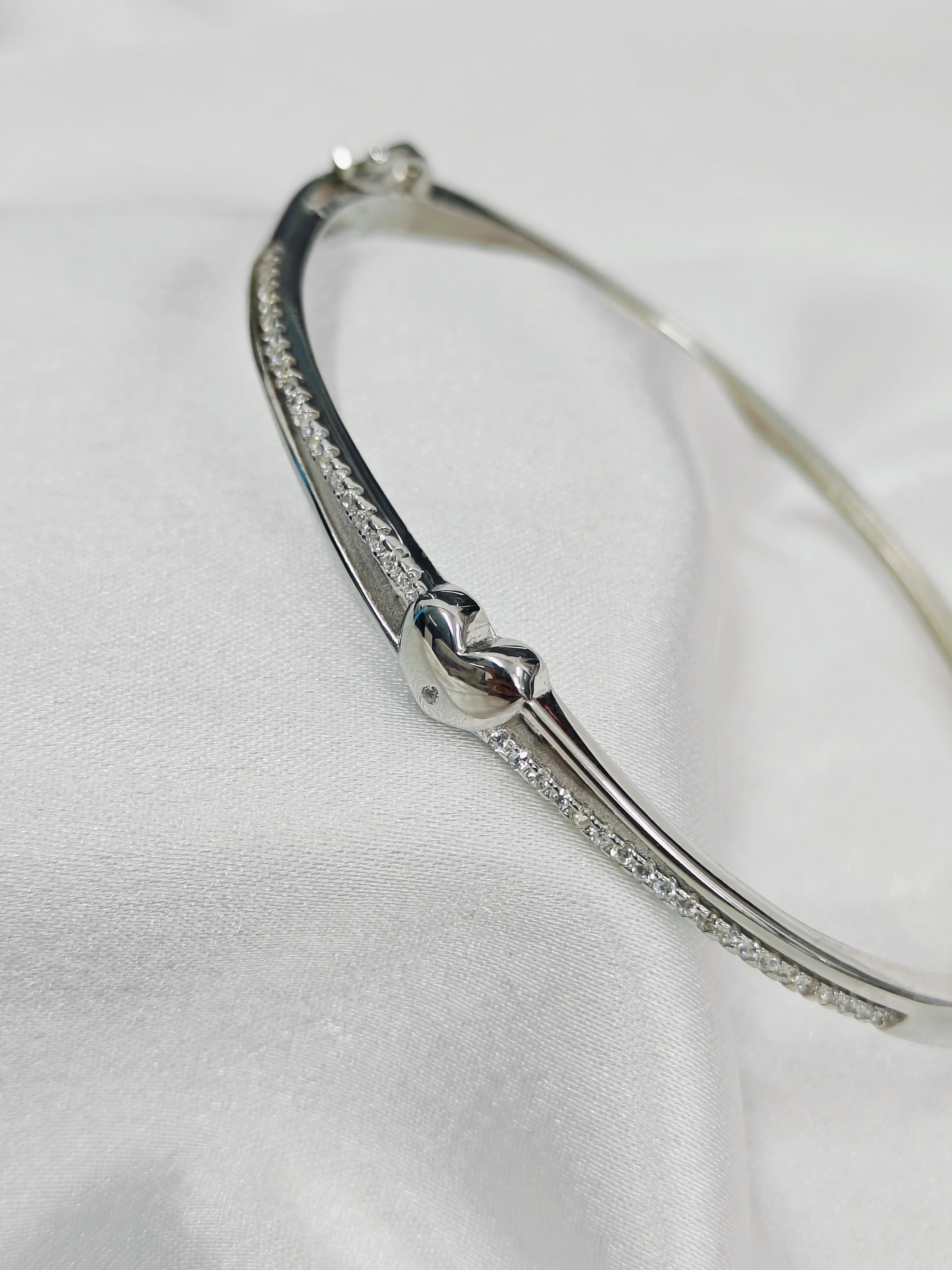 Silver bracelet with clear stones on a white background