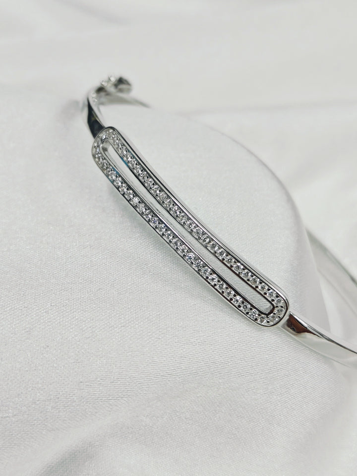 Silver bracelet with clear stones on a white fabric background