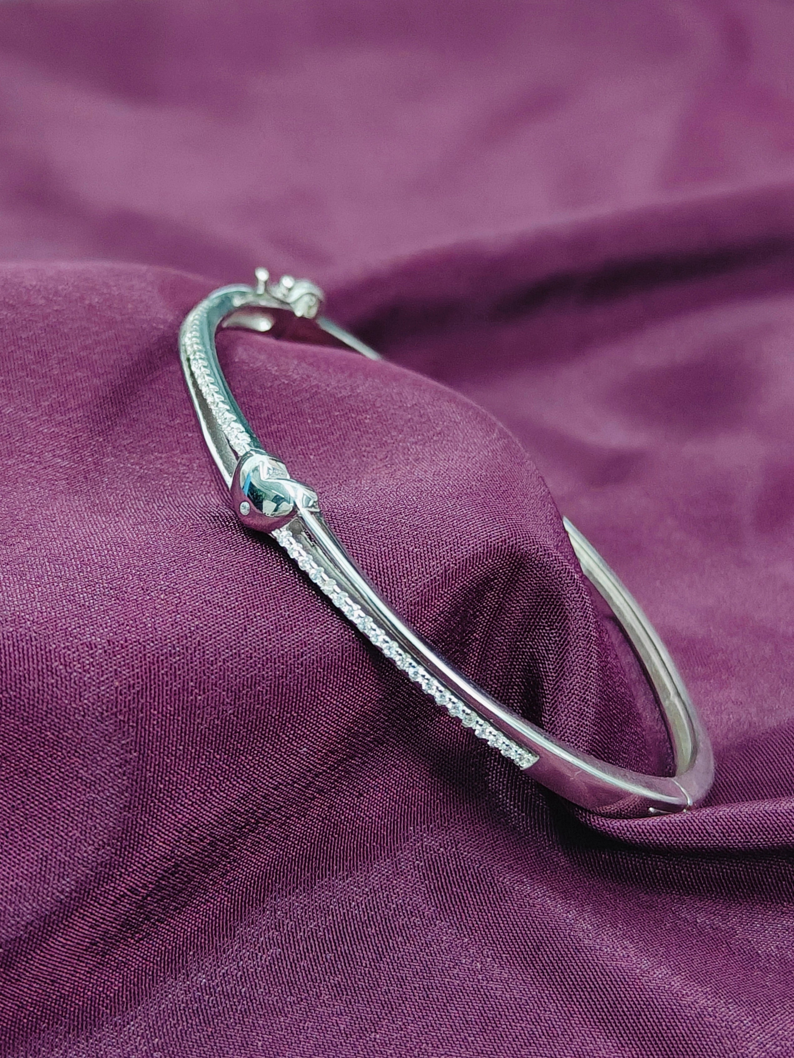 Silver bracelet on a purple fabric background