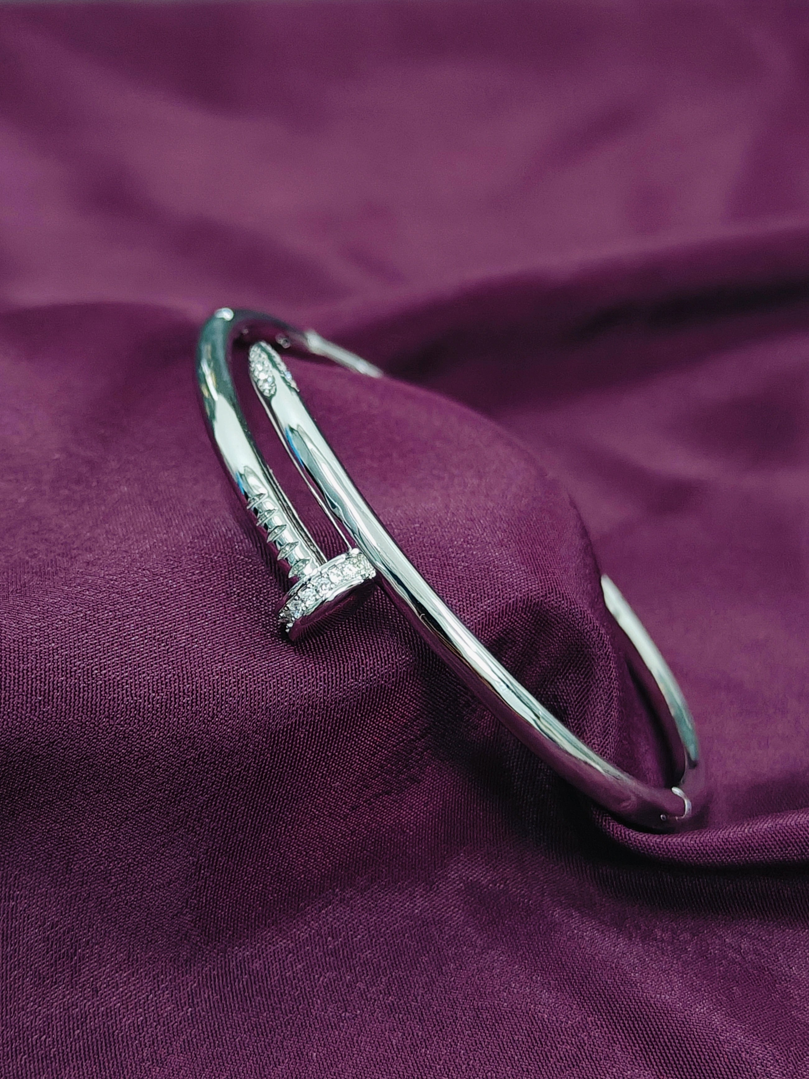 Silver bracelet with clear stones on a purple fabric background