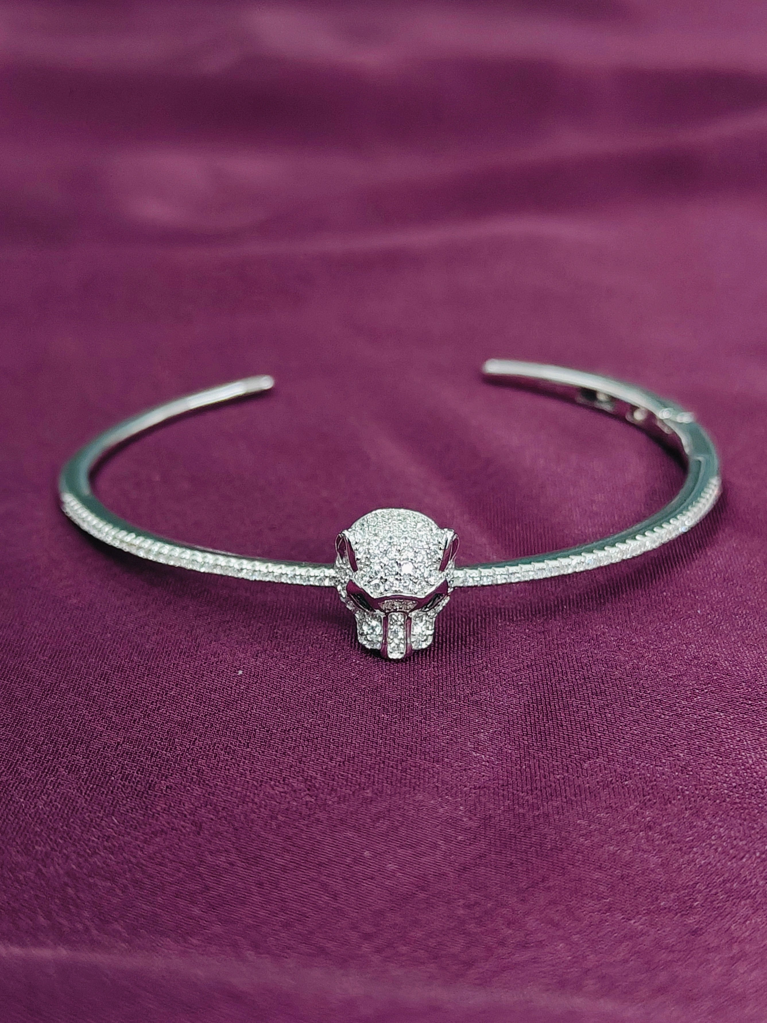 Silver bracelet with a decorative clasp on a purple fabric background