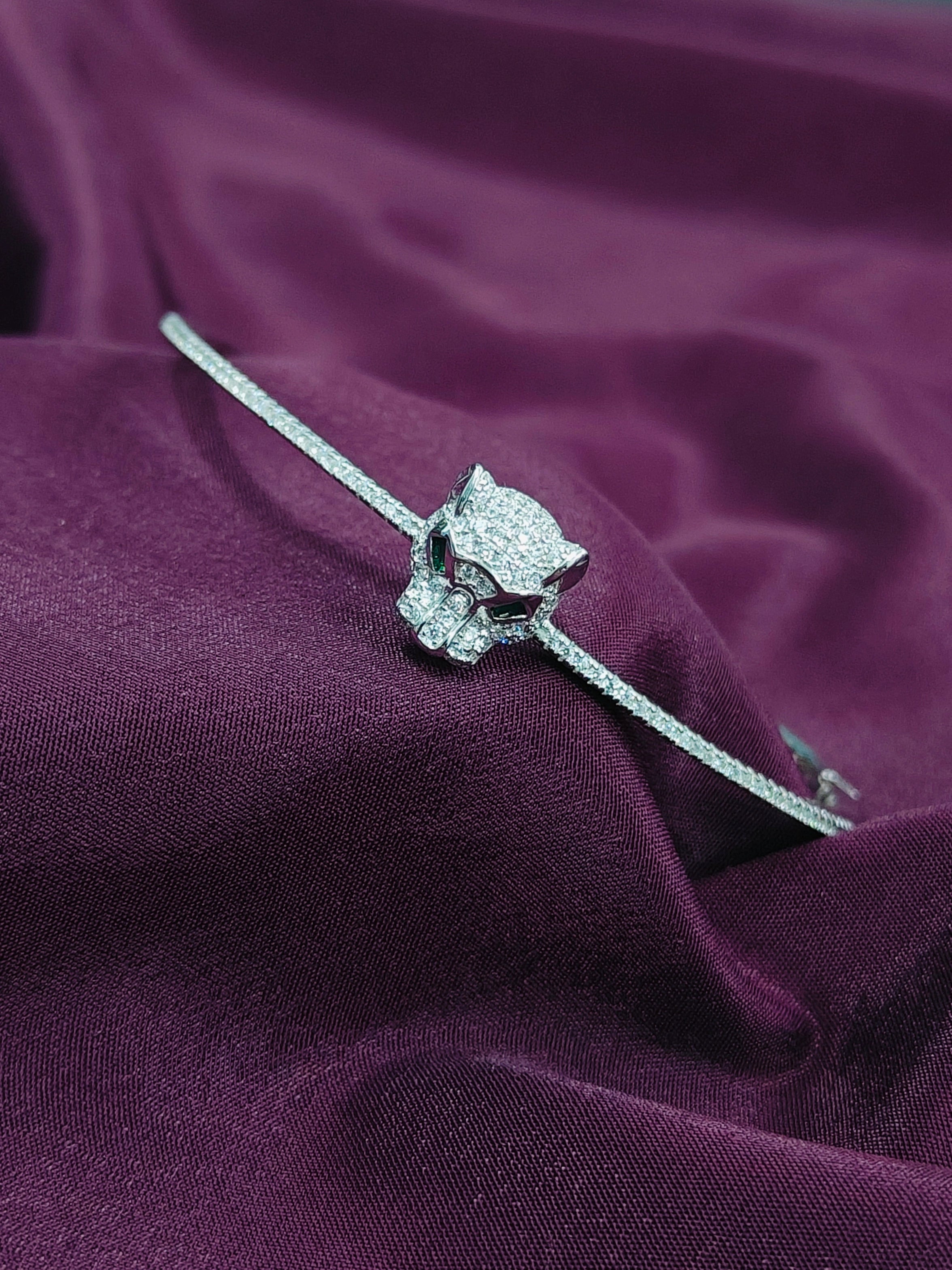 Silver bracelet with a diamond on a purple fabric background