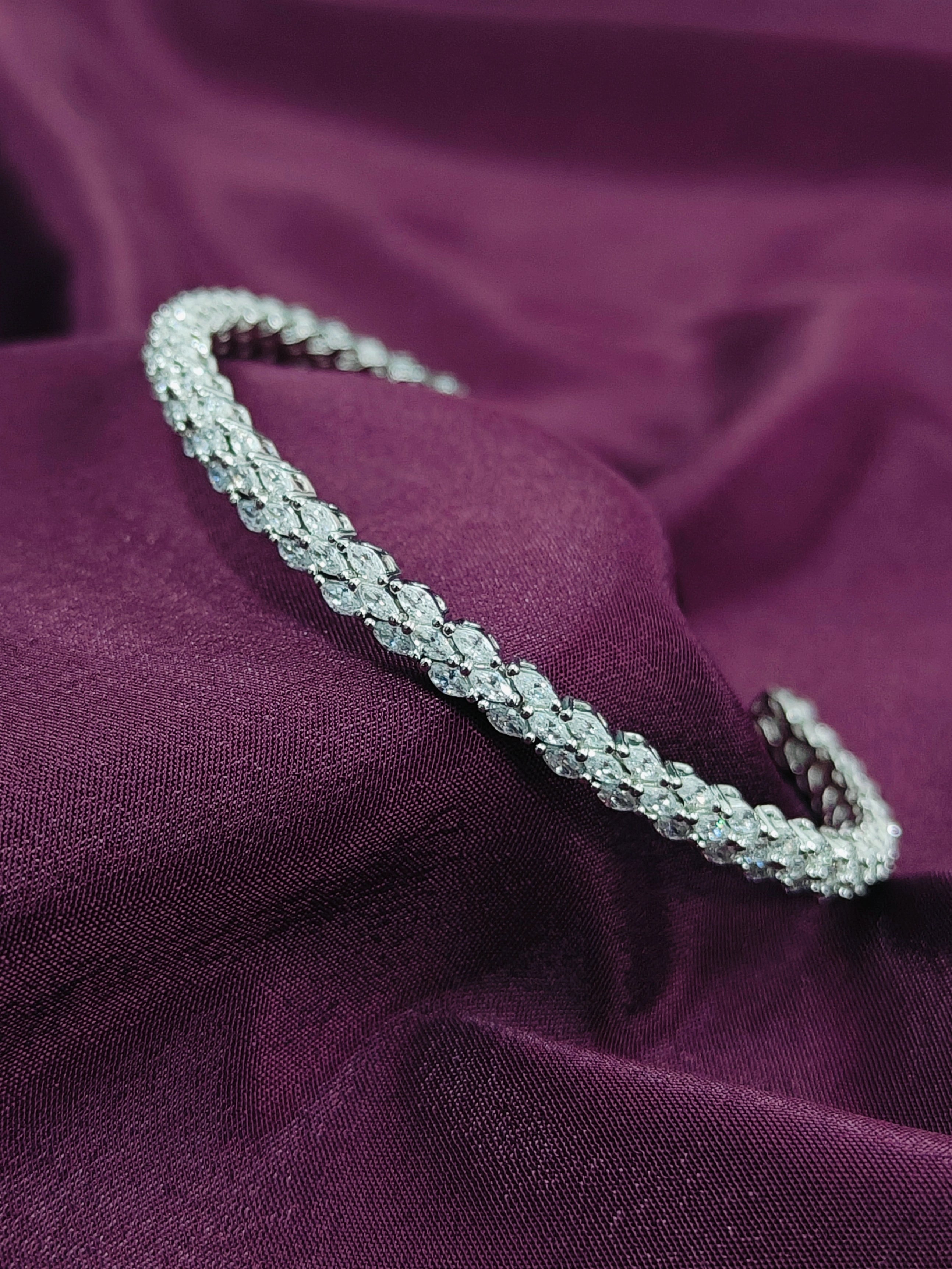 Silver bracelet on a purple fabric background