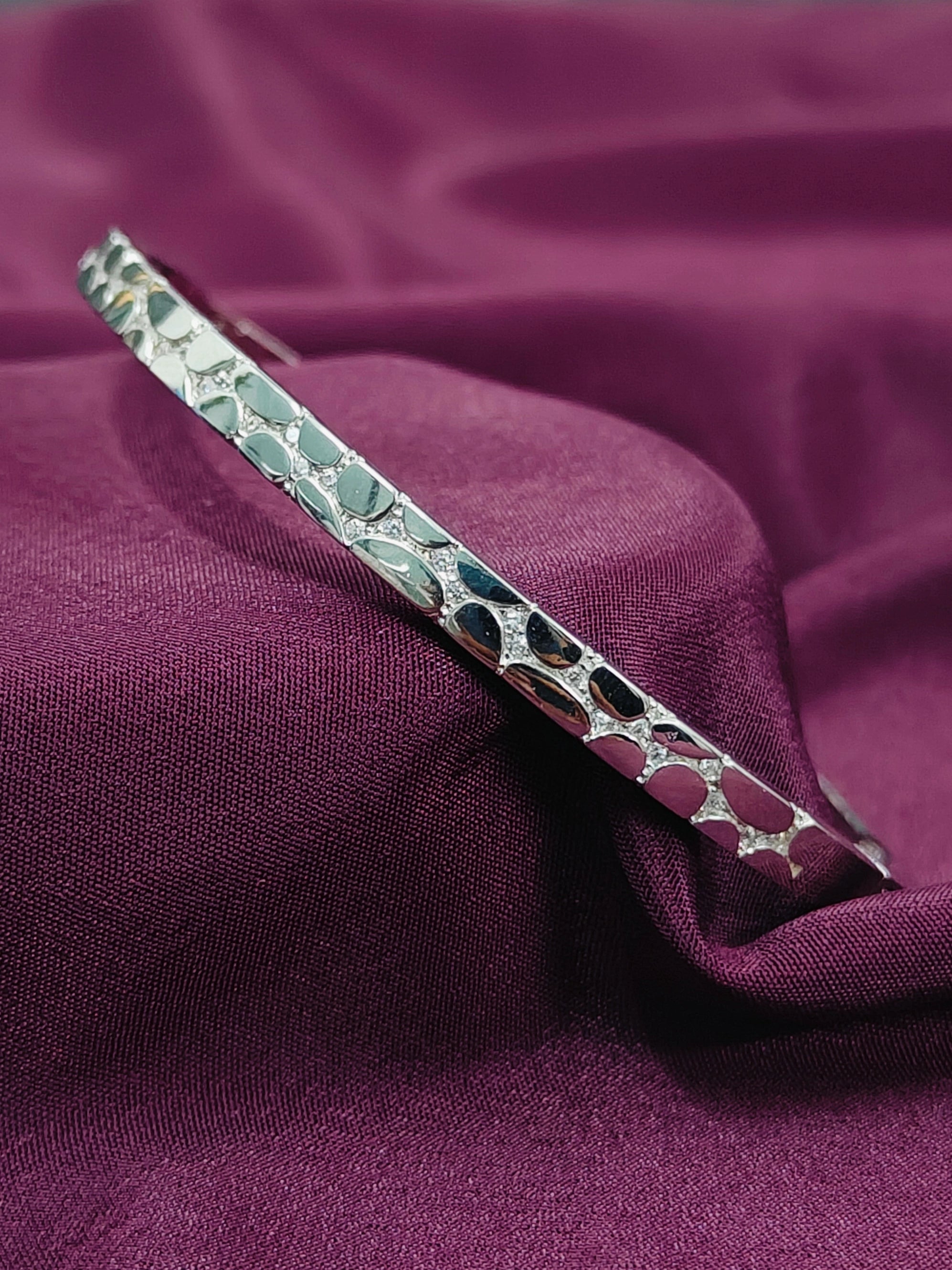 Decorative silver hairpin on a purple fabric background
