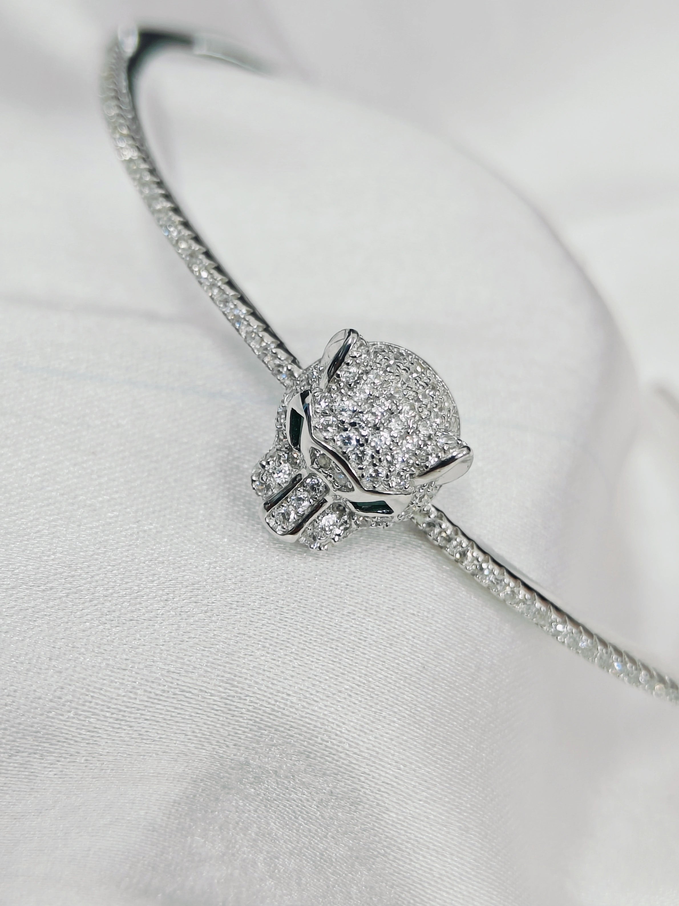 Silver bracelet with a heart-shaped clasp on a light gray background