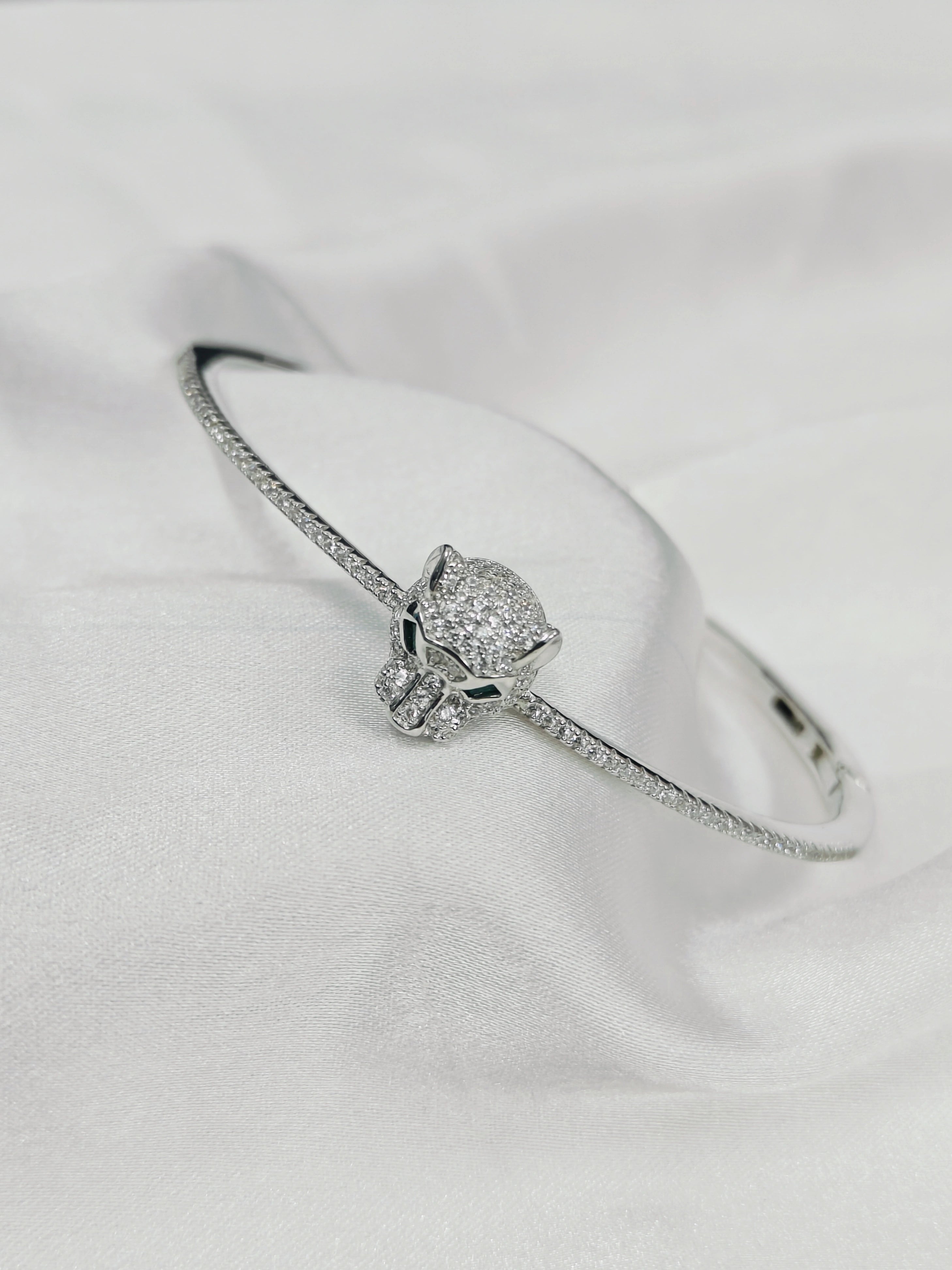 Silver bracelet with a skull design on a white background