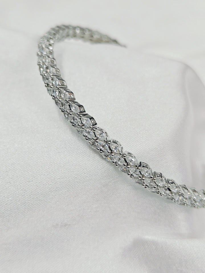 Silver headband with clear gemstones on a white background