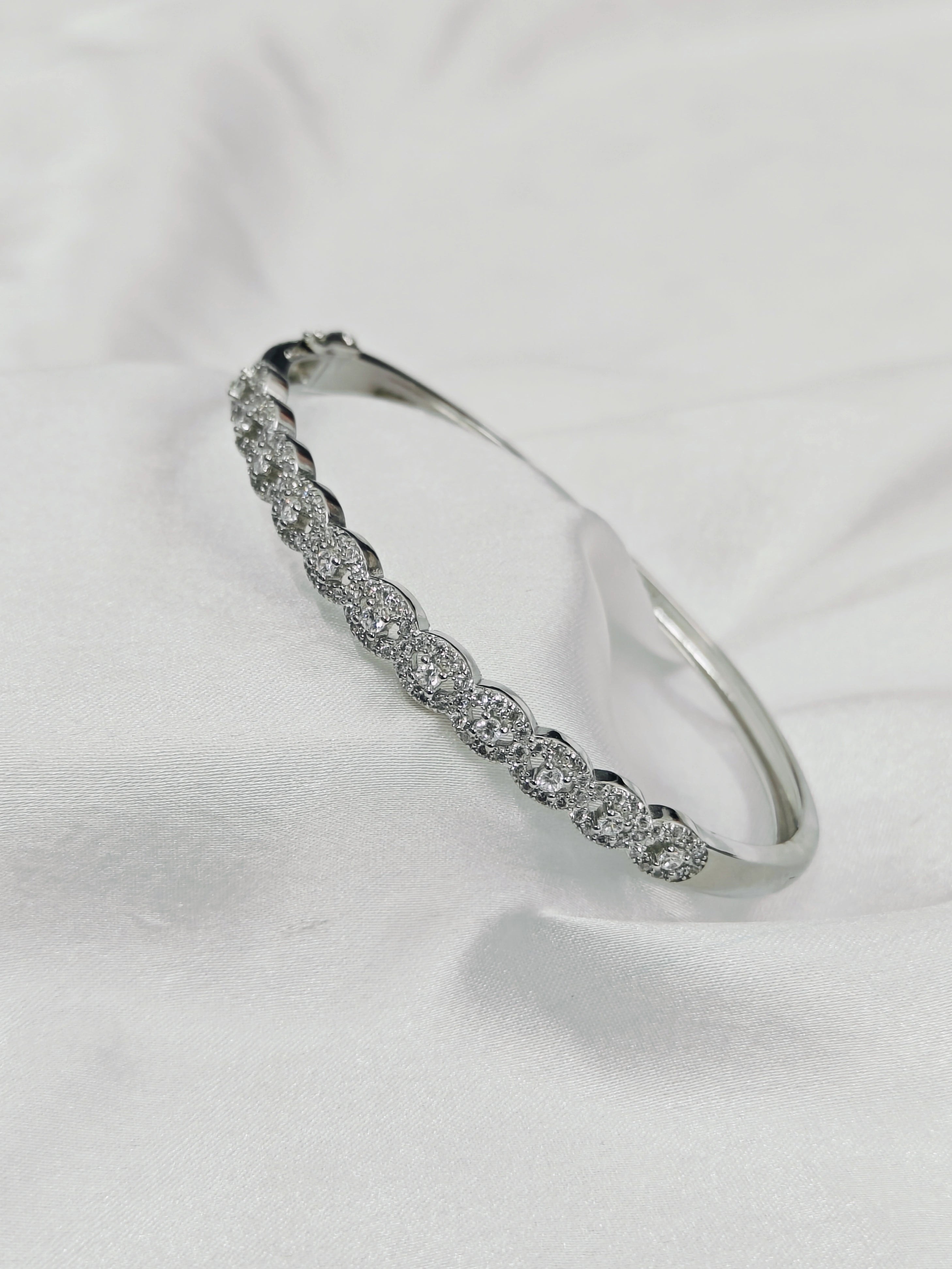 Silver bracelet with clear stones on a white background