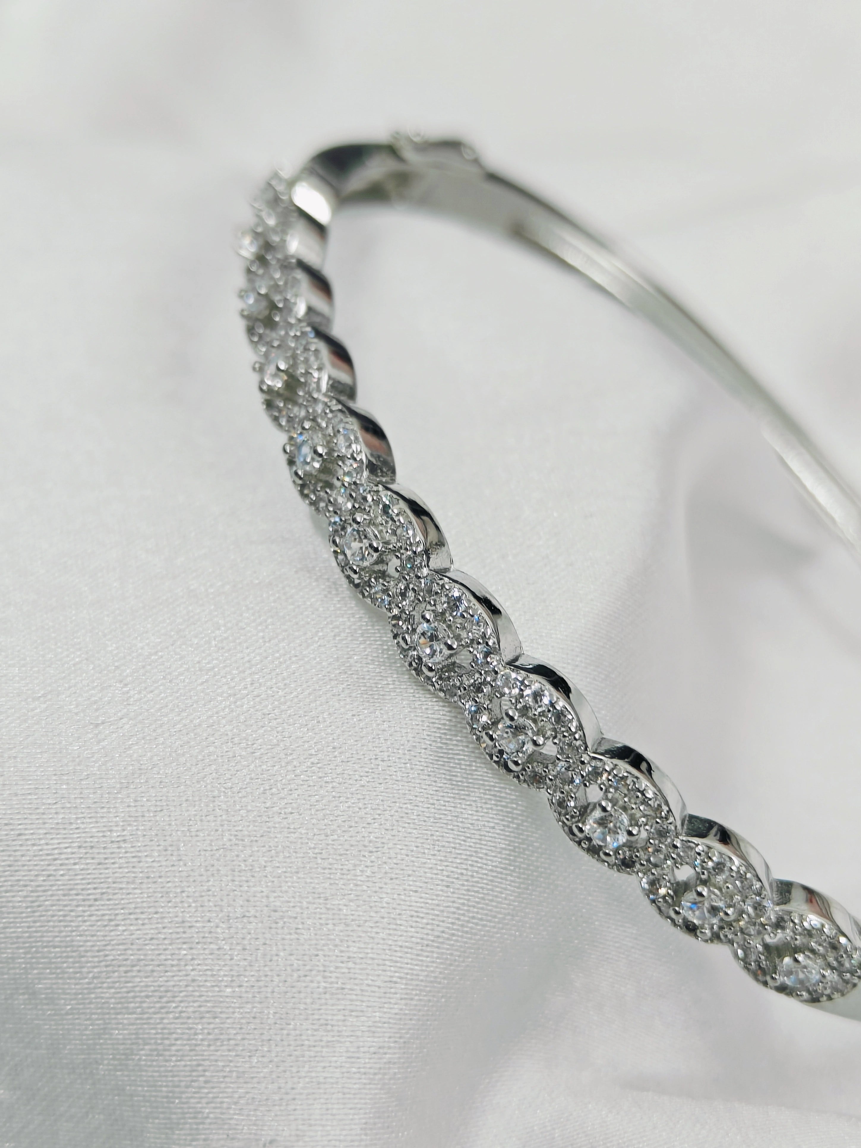 Silver bracelet with clear stones on a white background