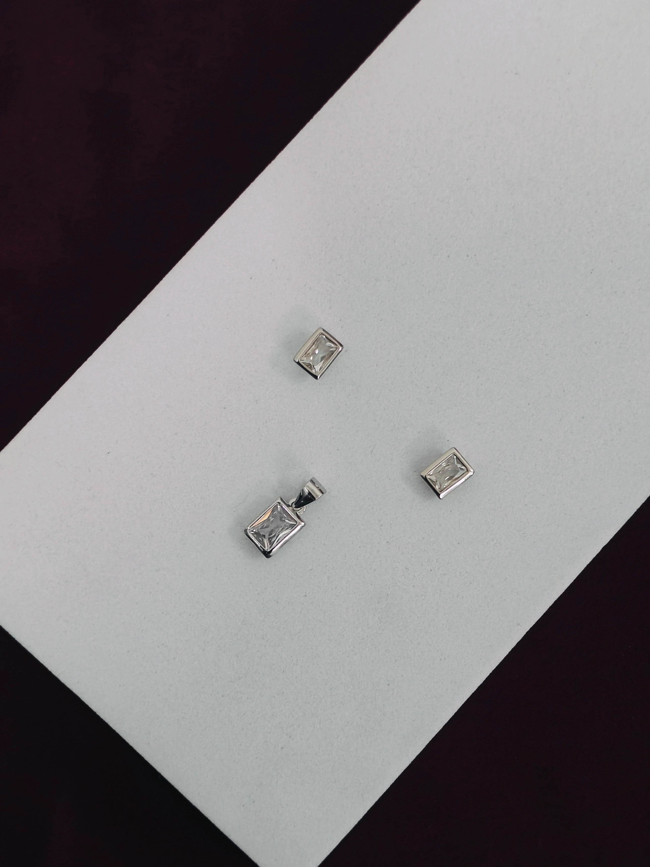 Silver square stud earrings on a light gray background
