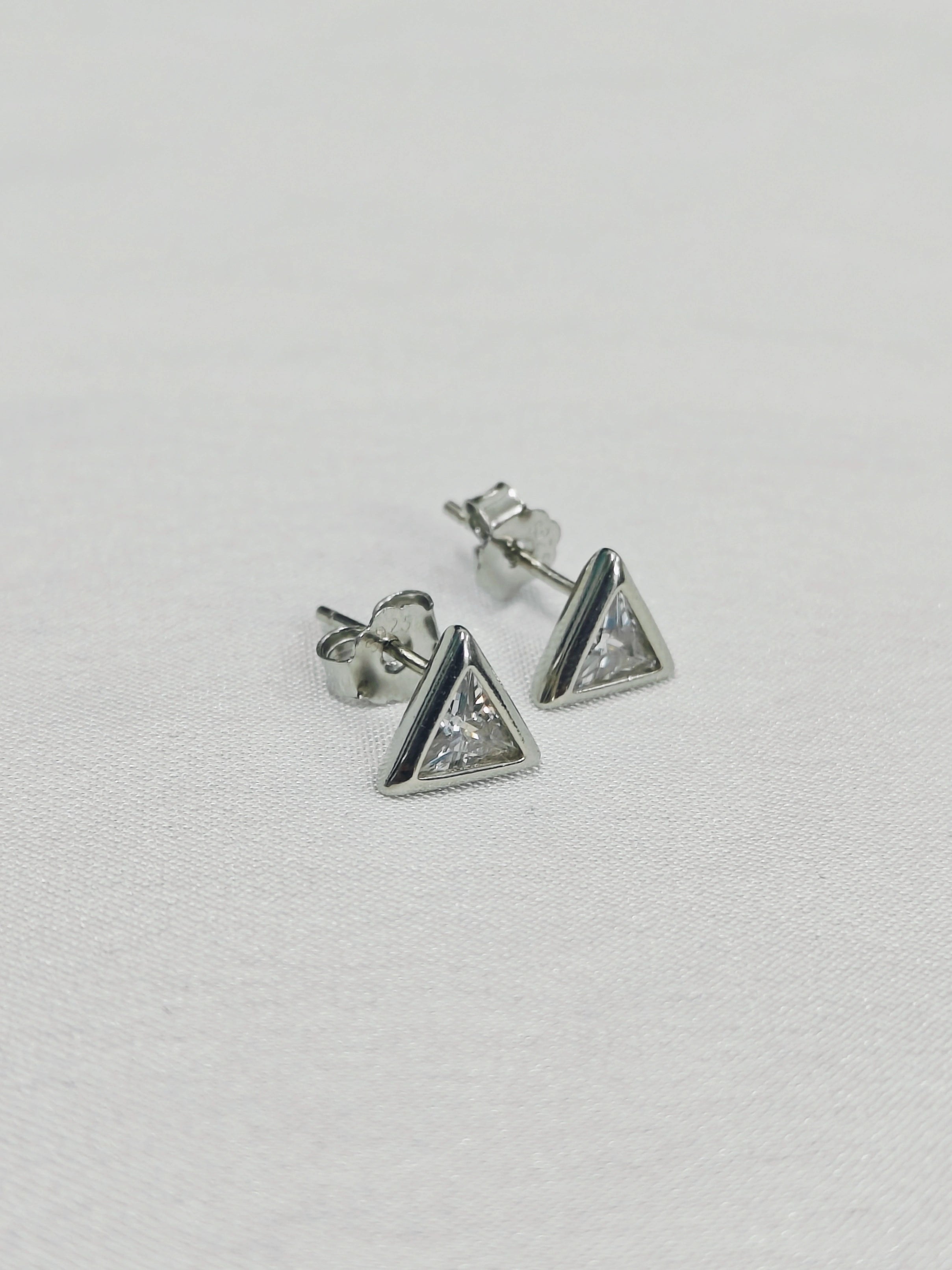 Pair of triangle-shaped stud earrings on a light gray background