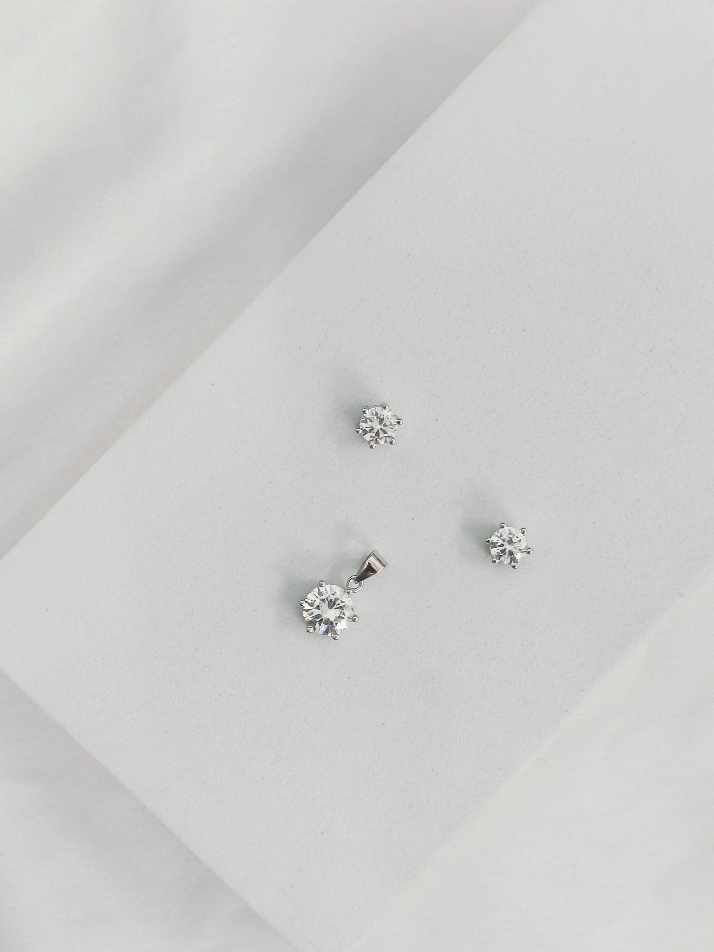 Silver stud earrings on a light gray background