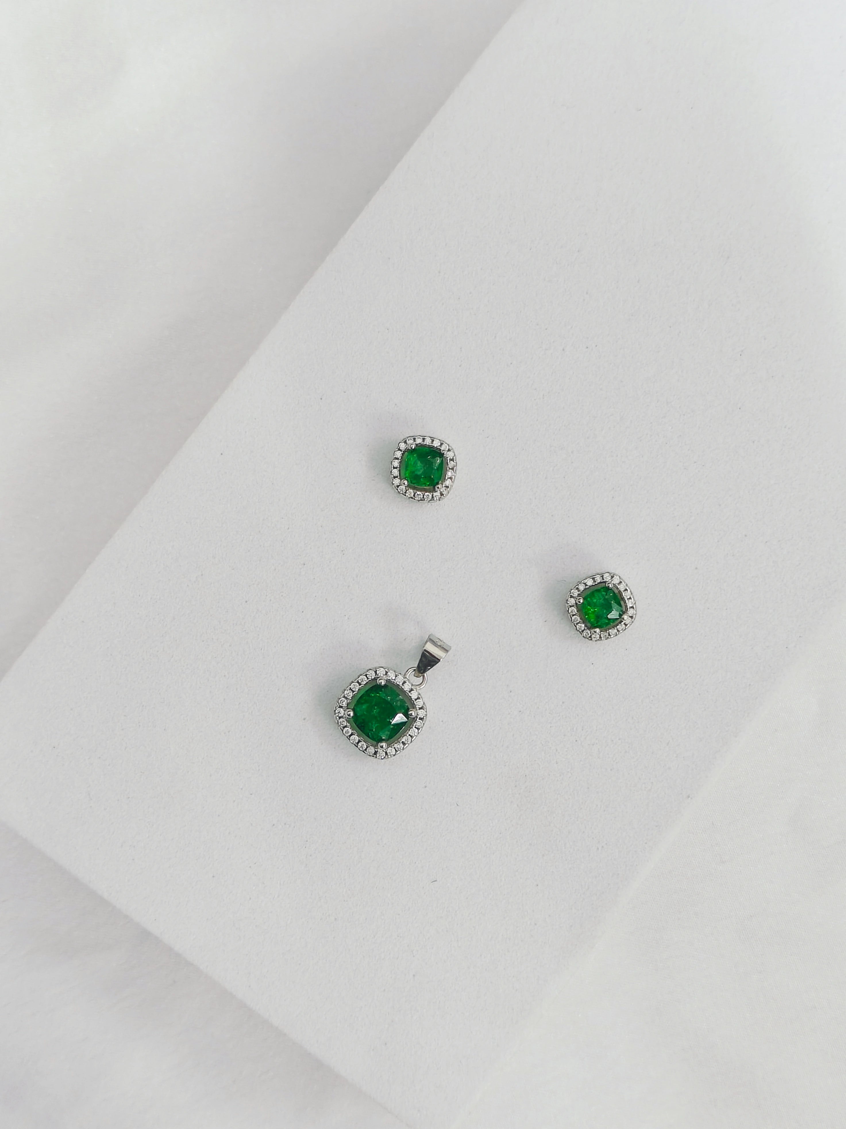 Green gemstone earrings on a light gray background