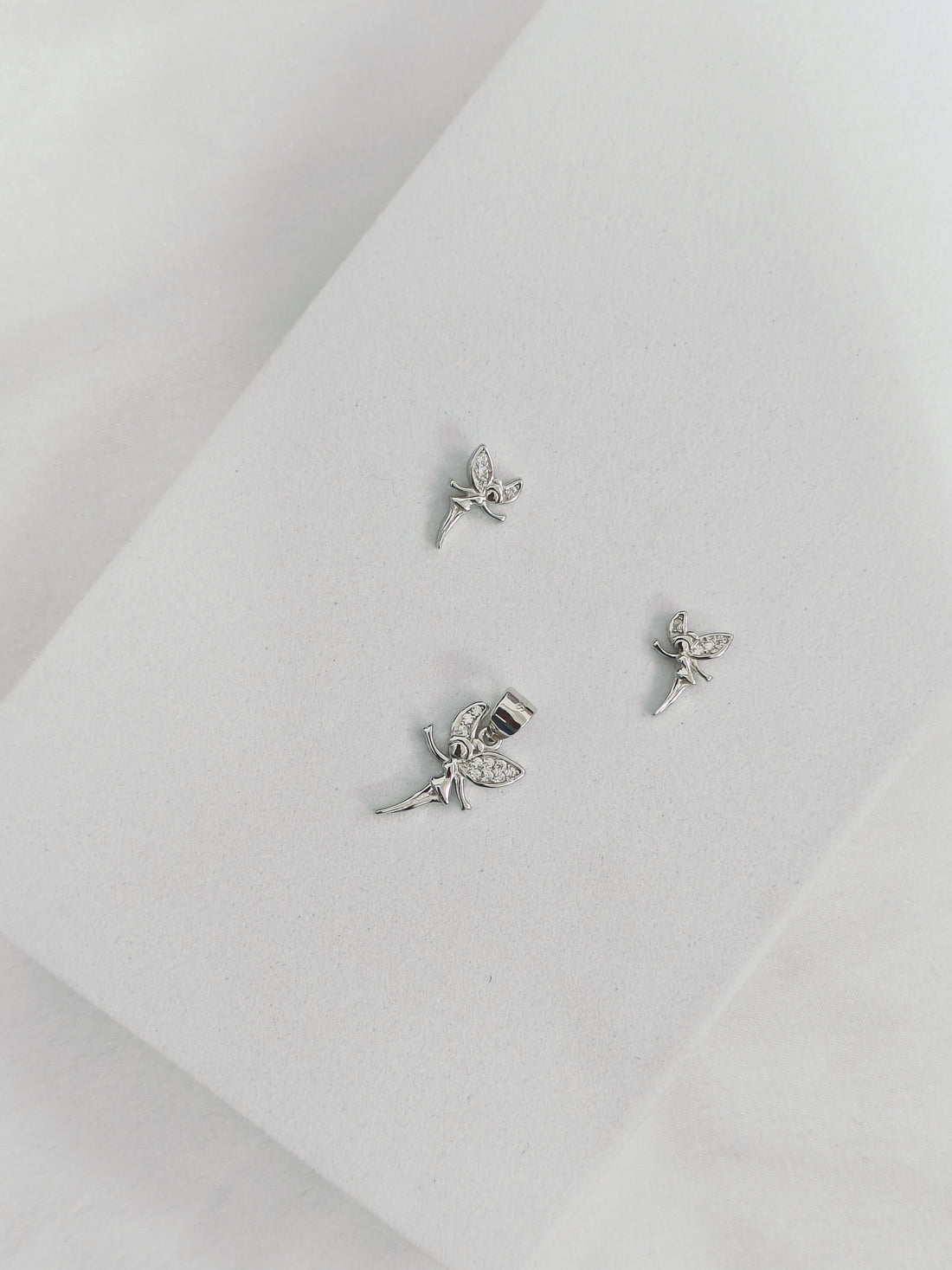 Silver fairy earrings on a light gray background