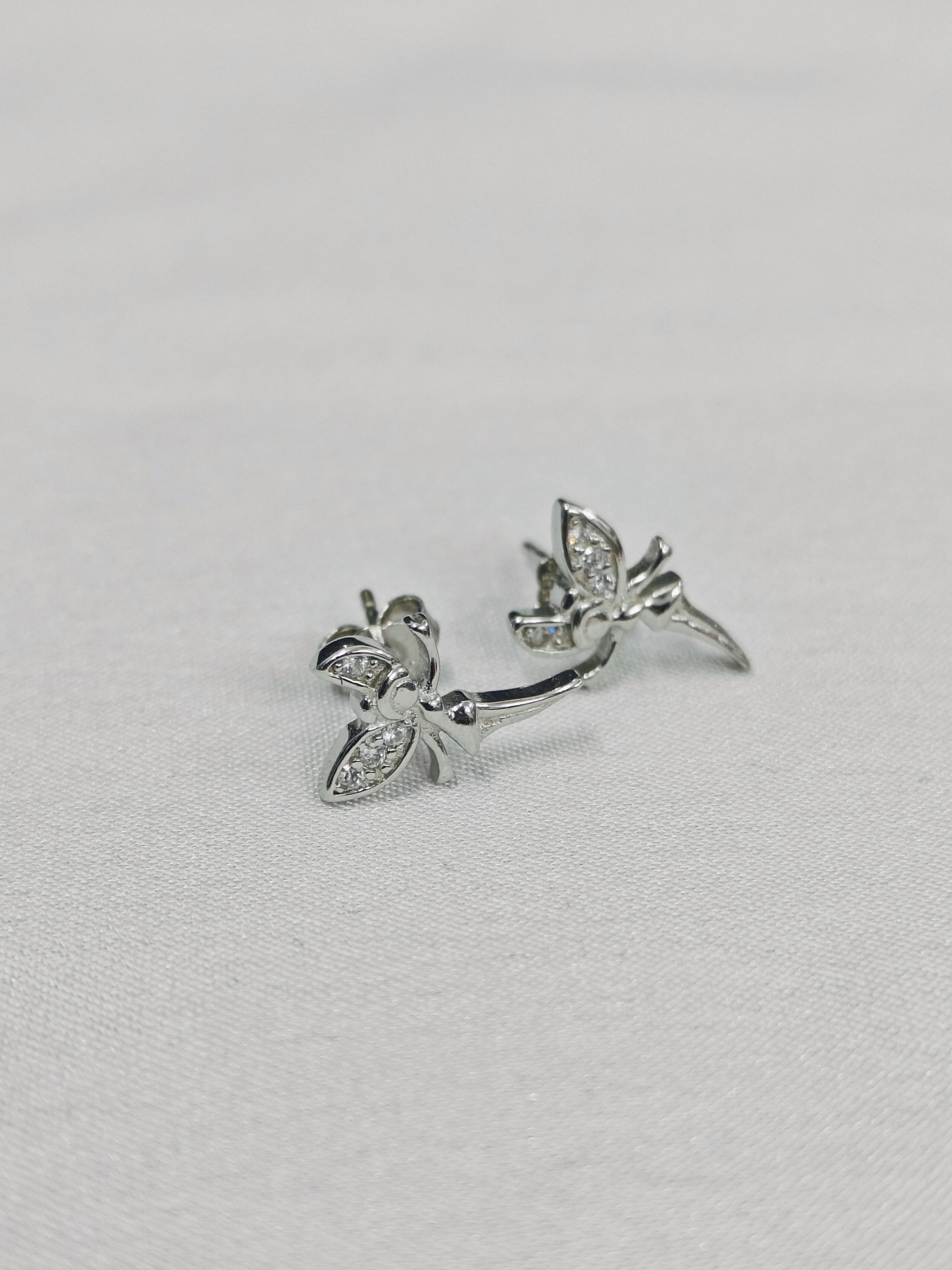 Pair of silver hummingbird earrings on a light gray background