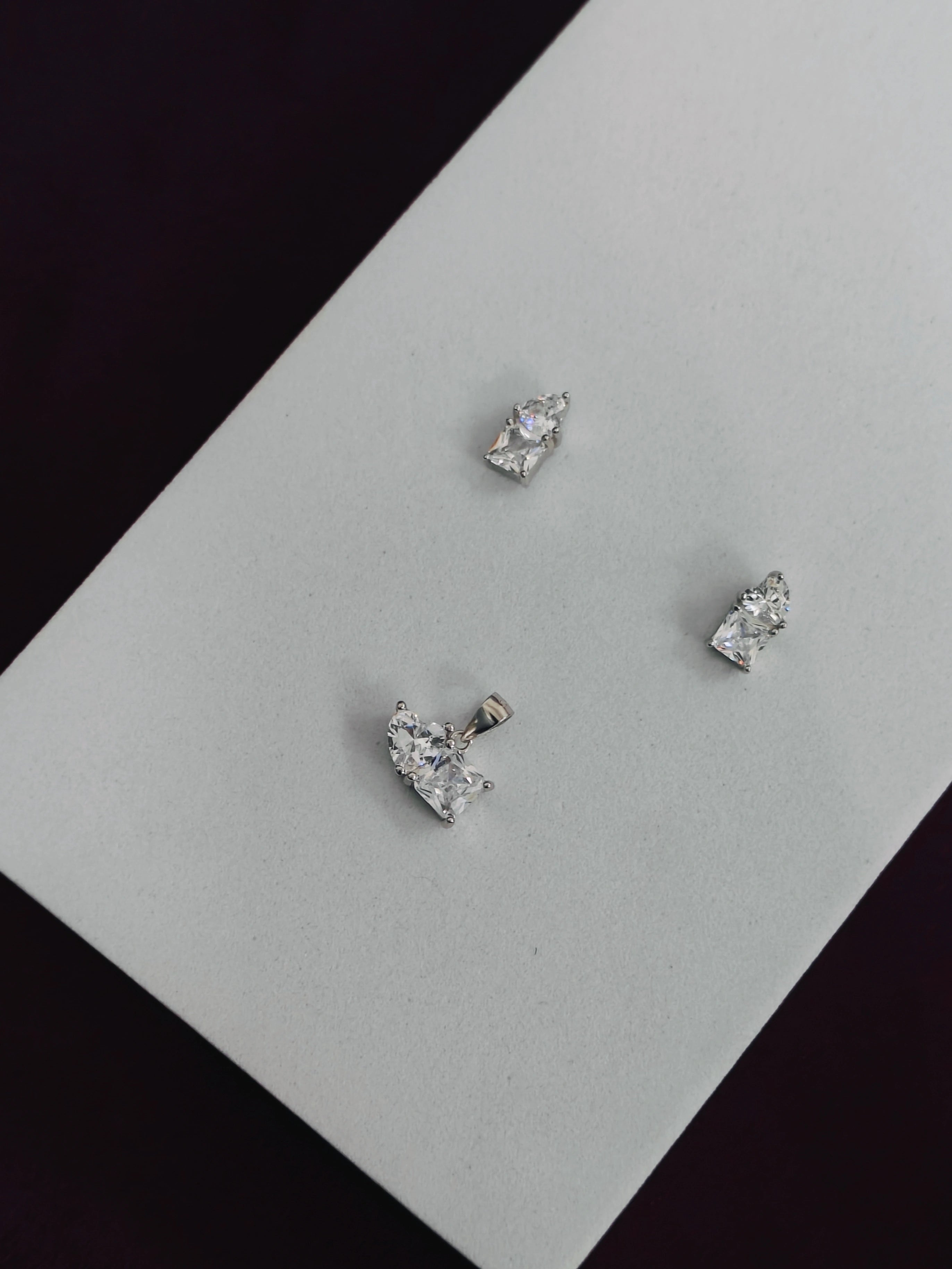 Four diamond stud earrings on a light gray card with a black background
