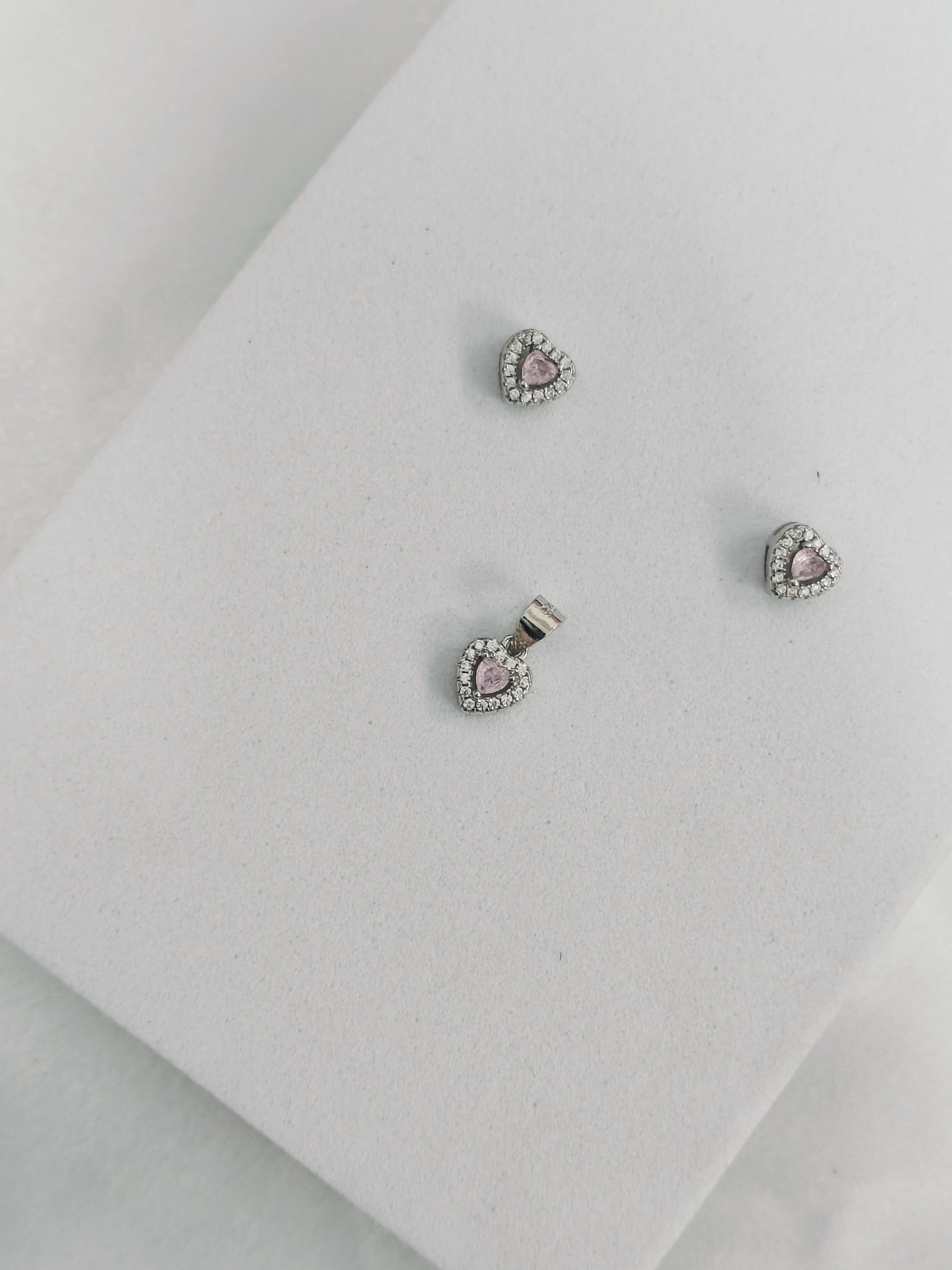 Pair of earrings with pink gemstones on a light gray background