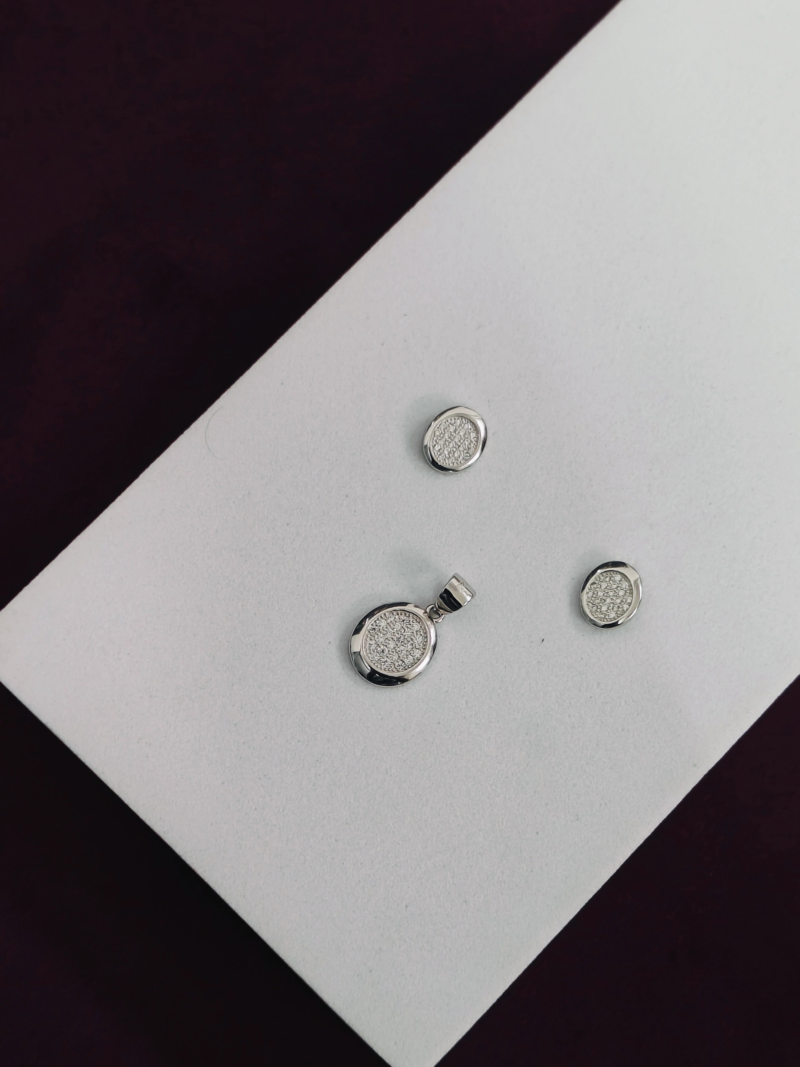 Silver jewelry set on a white card with a black background