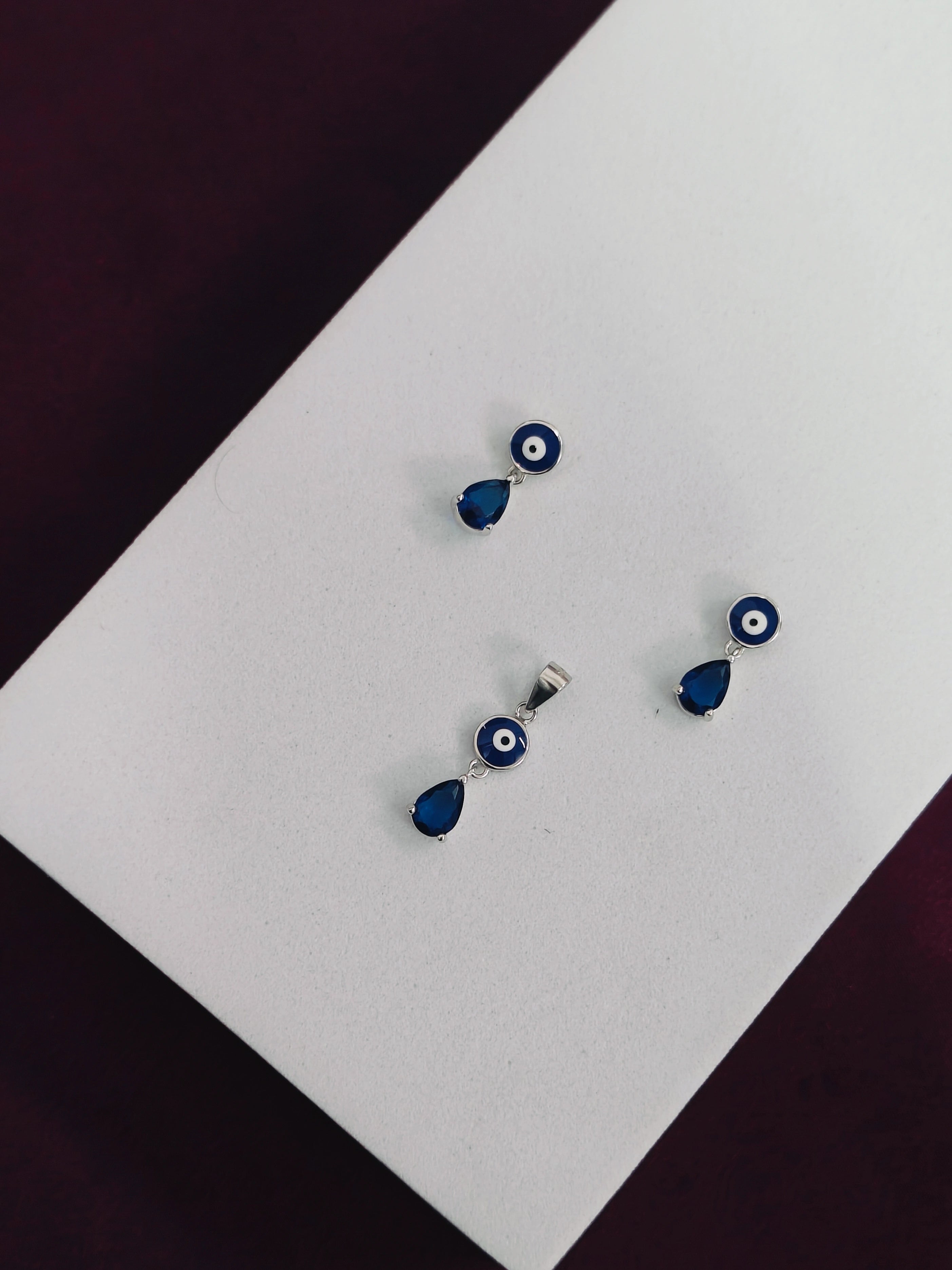 Pair of blue teardrop earrings with silver accents on a white surface.