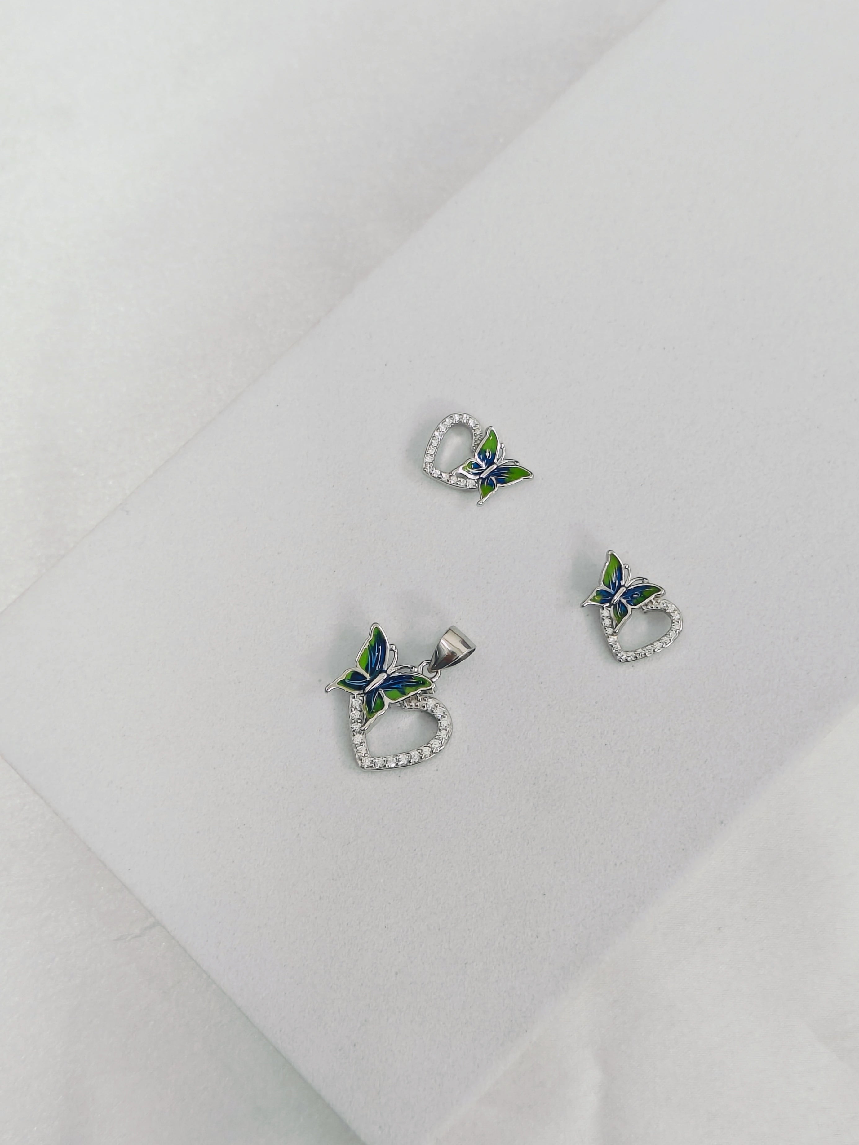 Butterfly-shaped earrings with blue and green details on a white background