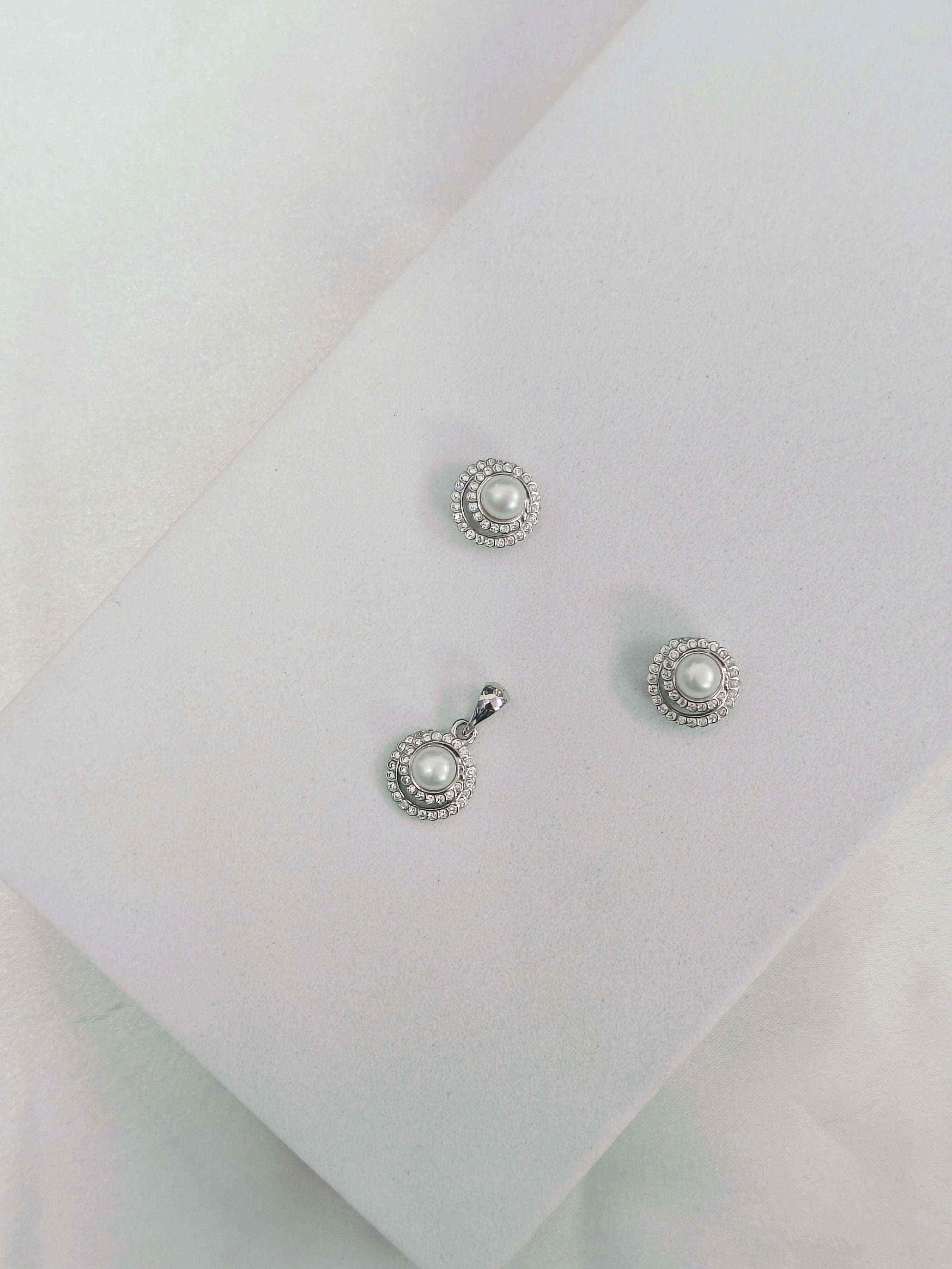 Pair of pearl earrings on a light gray background