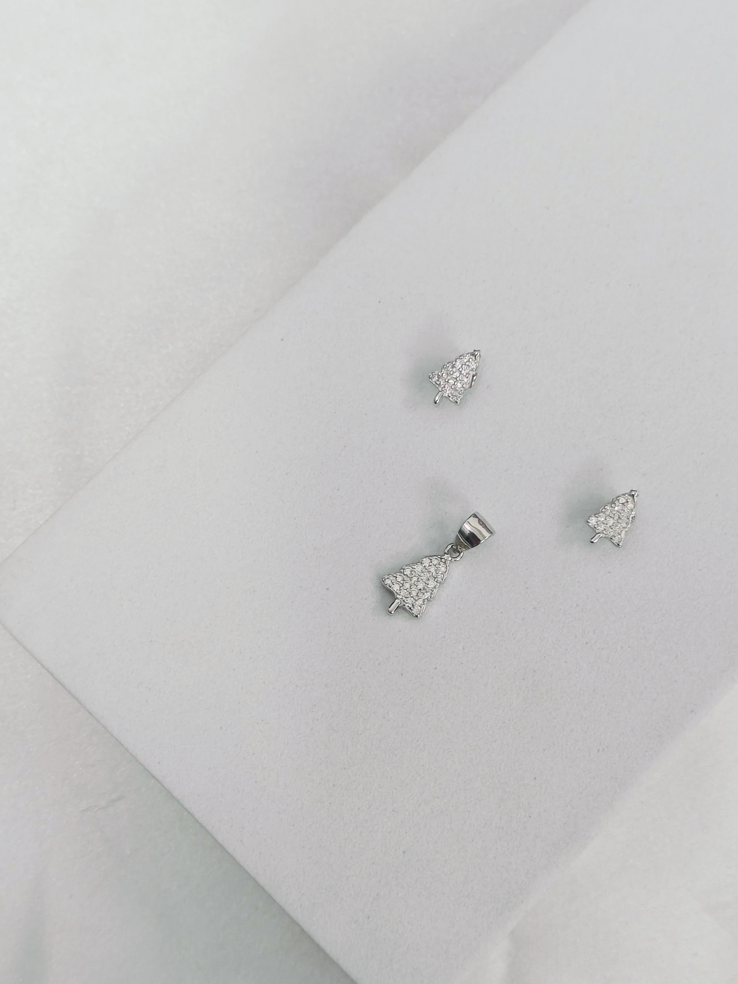 Pair of silver bow-shaped earrings on a light gray background
