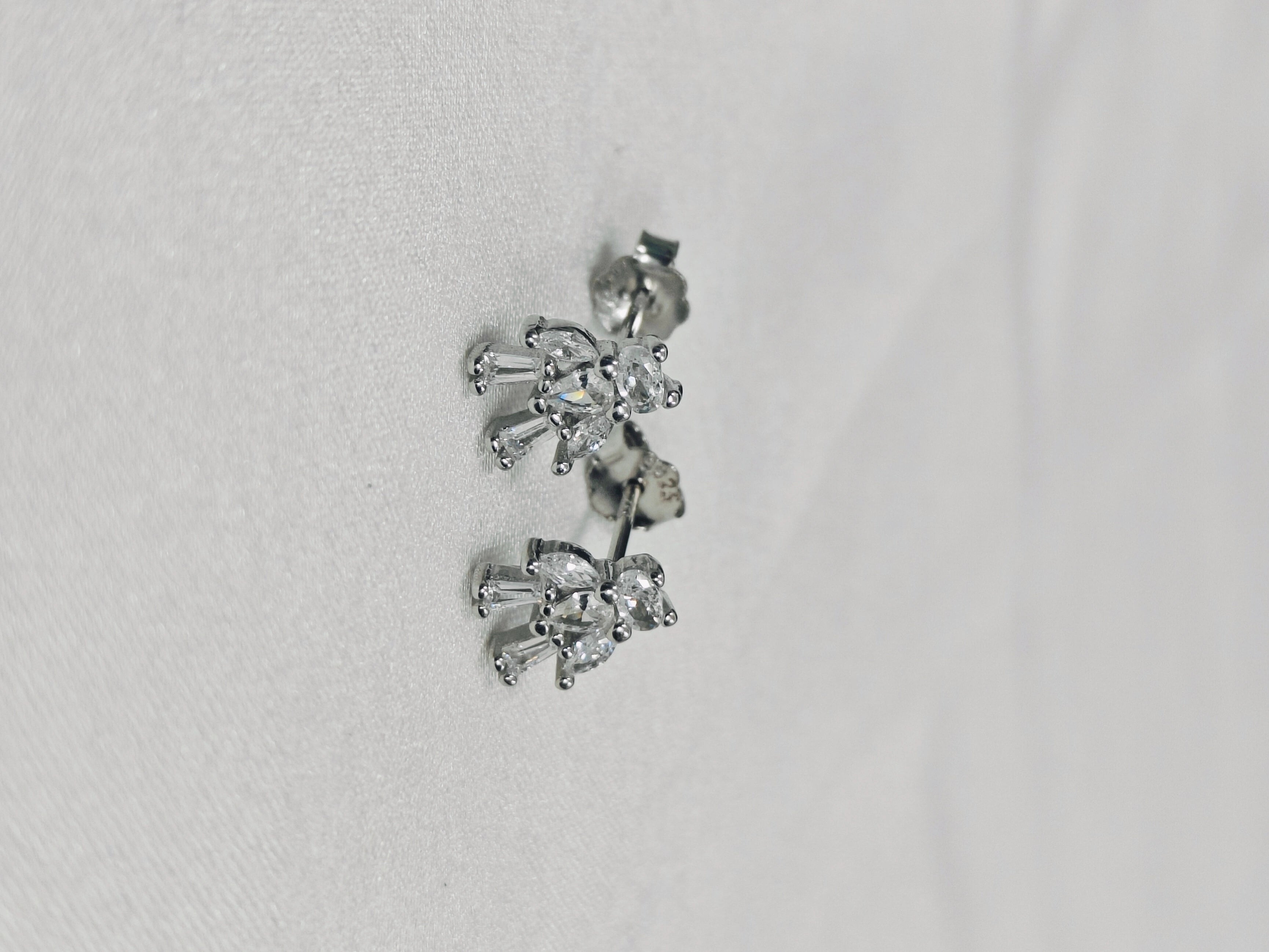 Pair of silver earrings on a light gray background