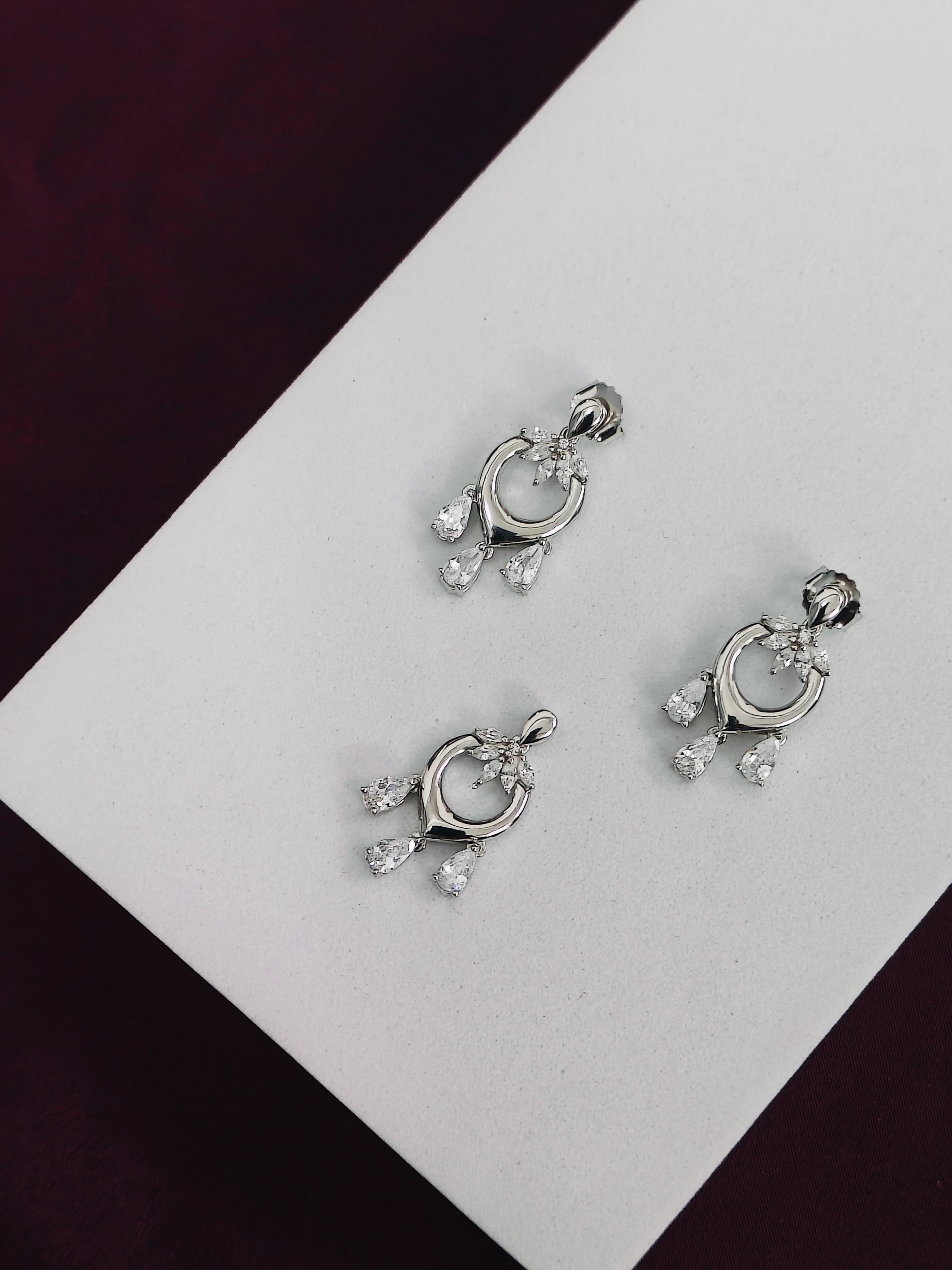 Silver earrings with gemstones on a white card