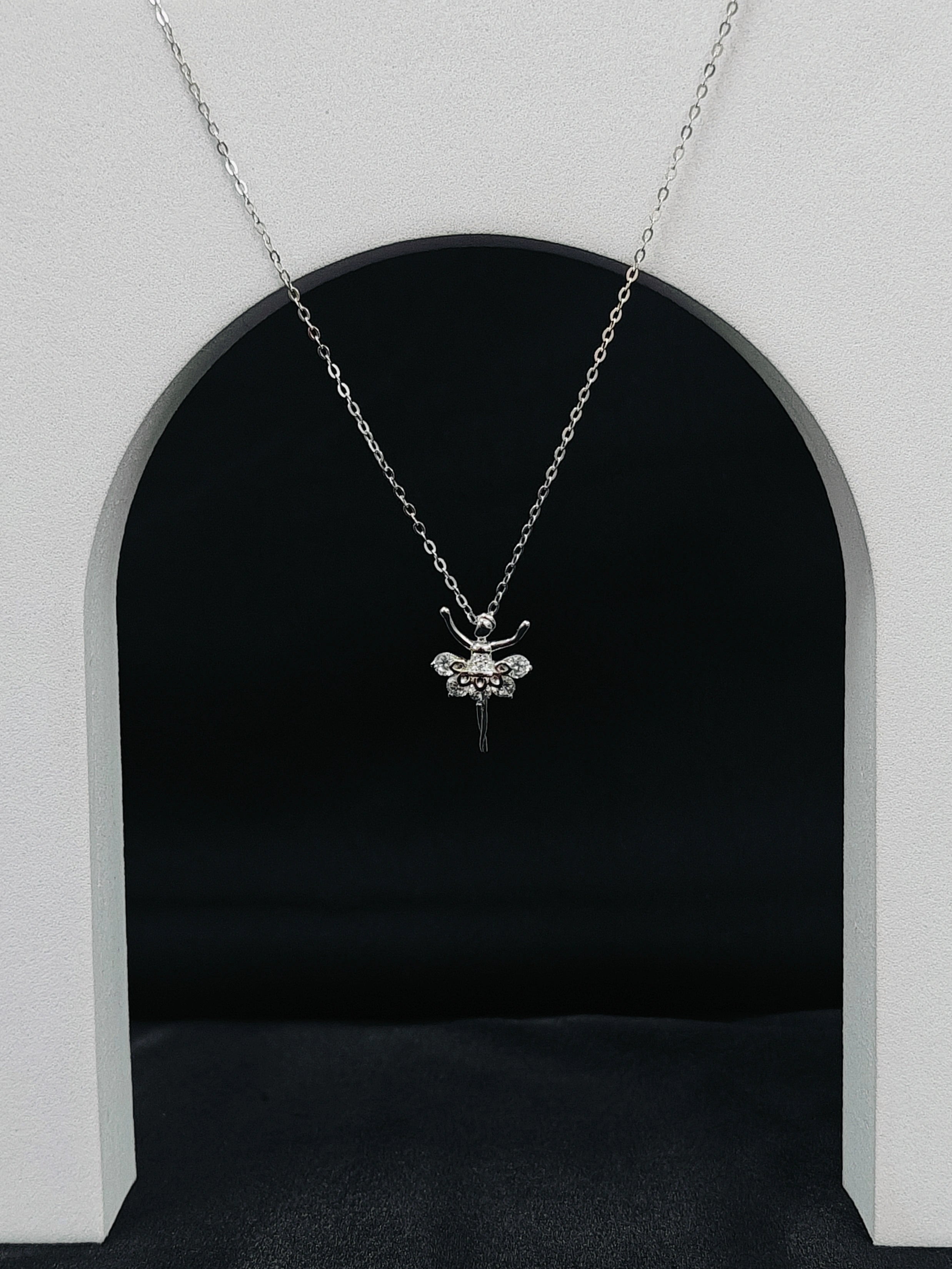 Silver bee pendant necklace on a chain against a black background