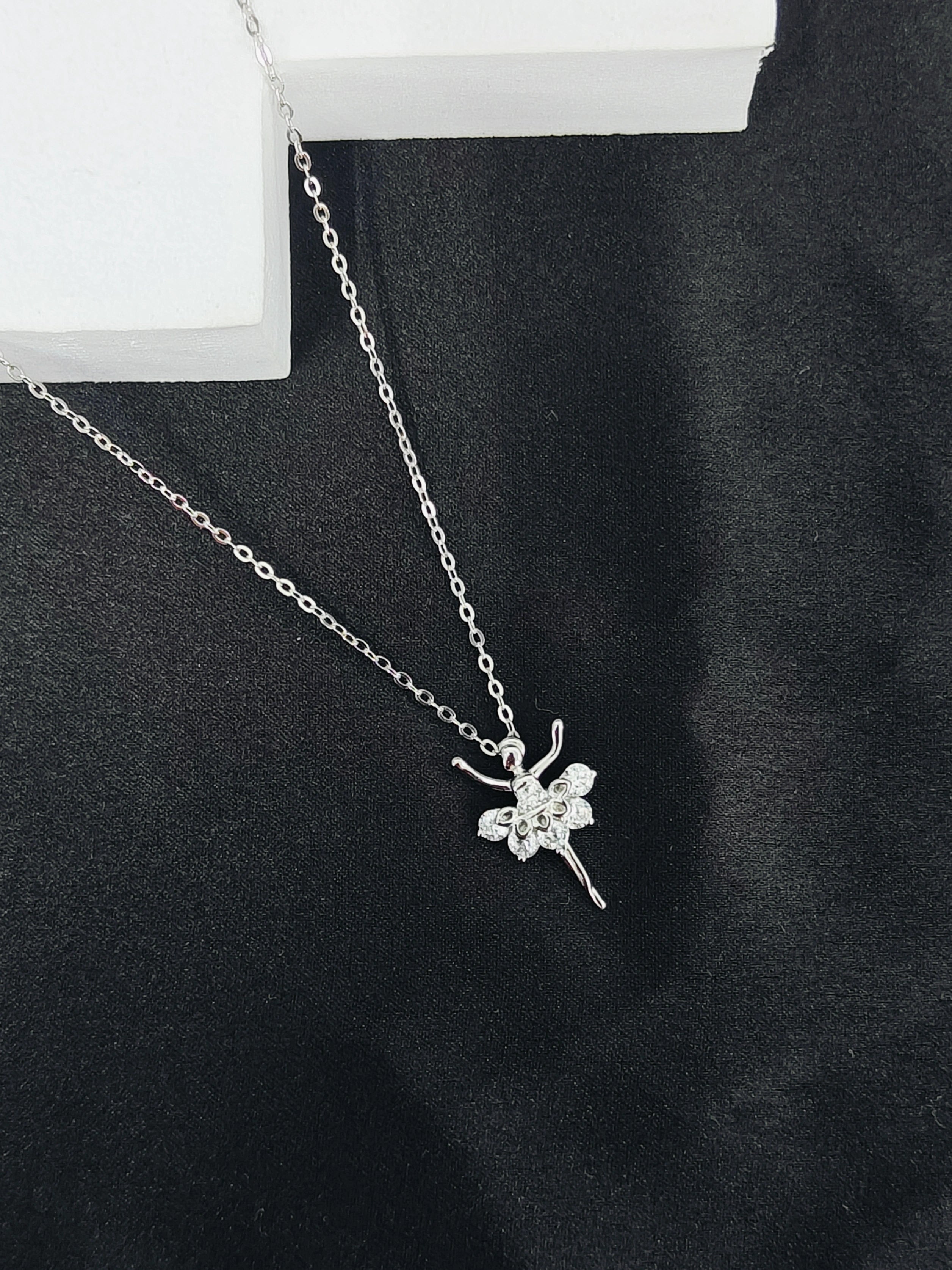 Silver necklace with a butterfly pendant on a black background