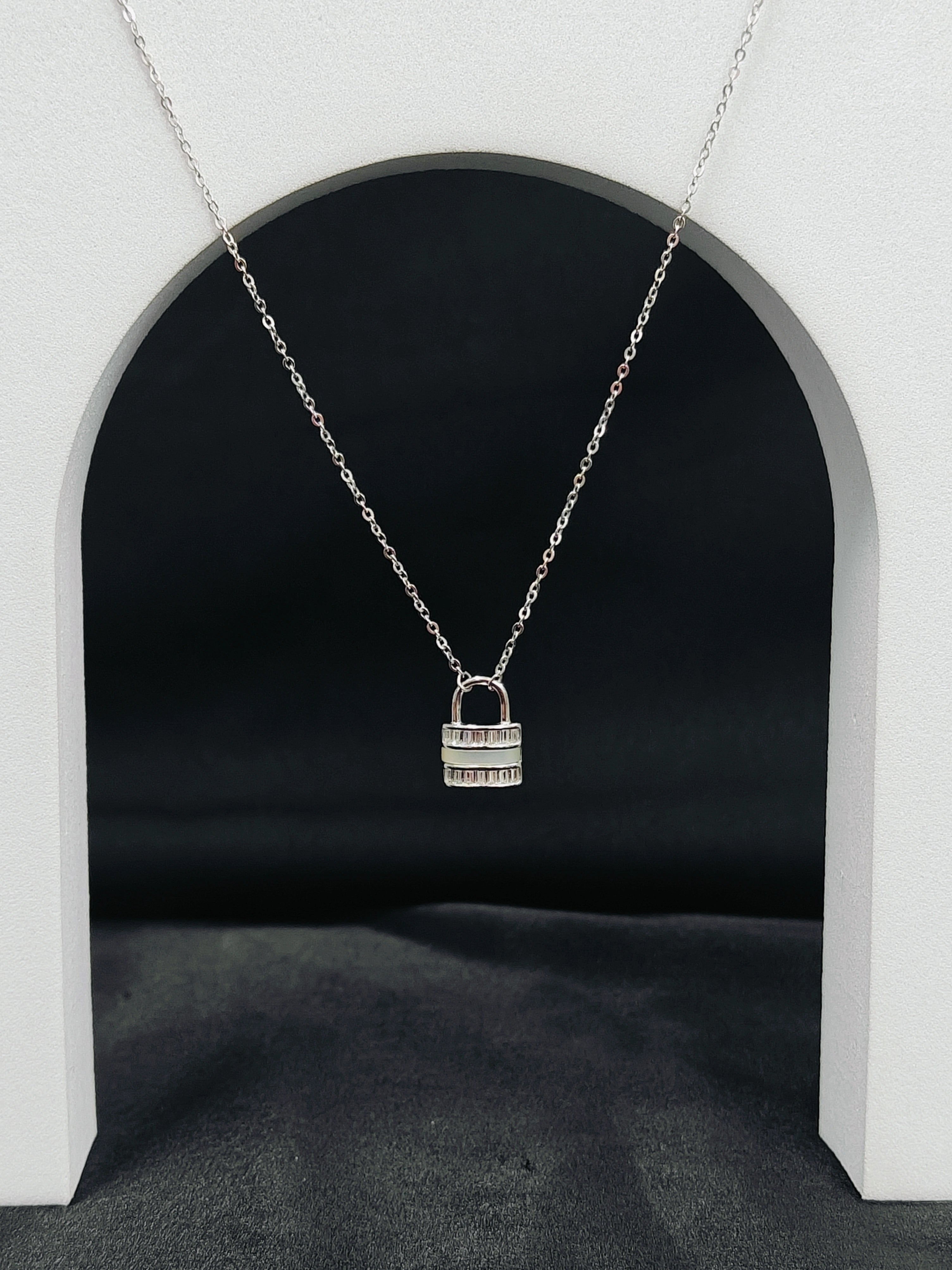 Silver padlock necklace on a dark background
