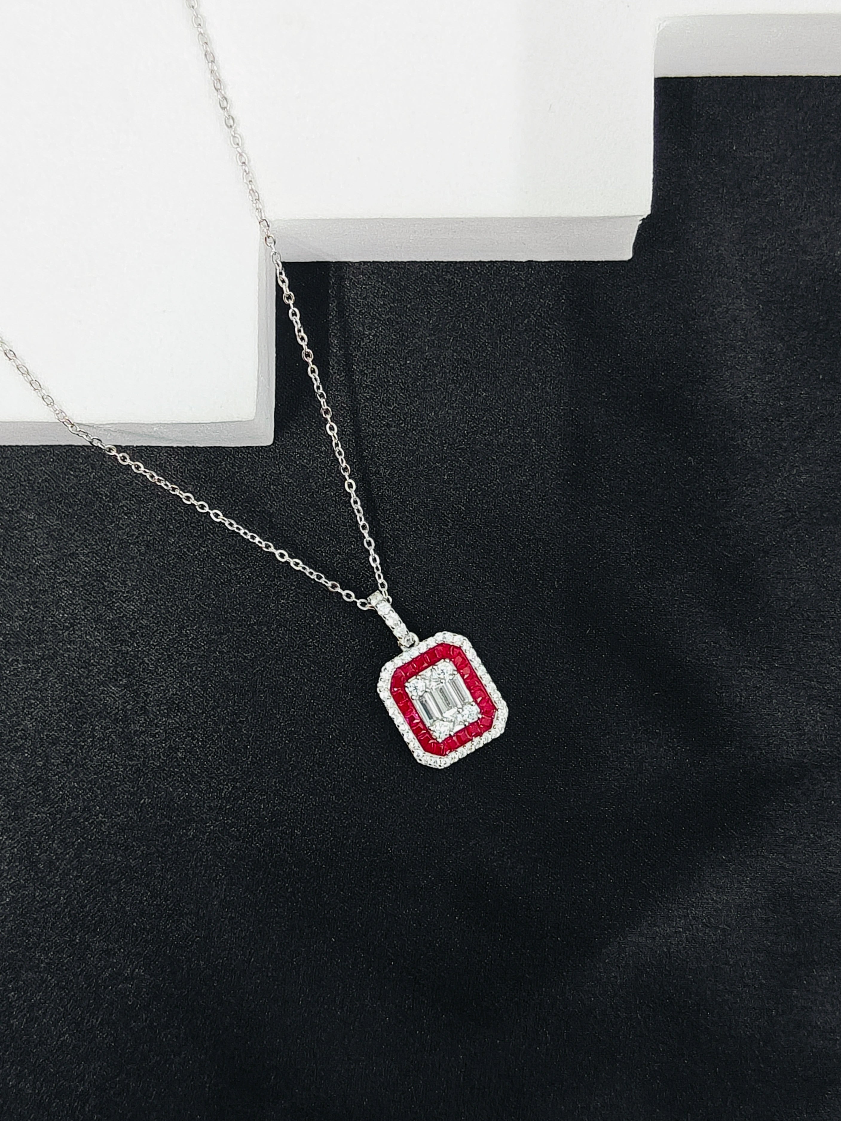 Necklace with a red and silver pendant on a black surface