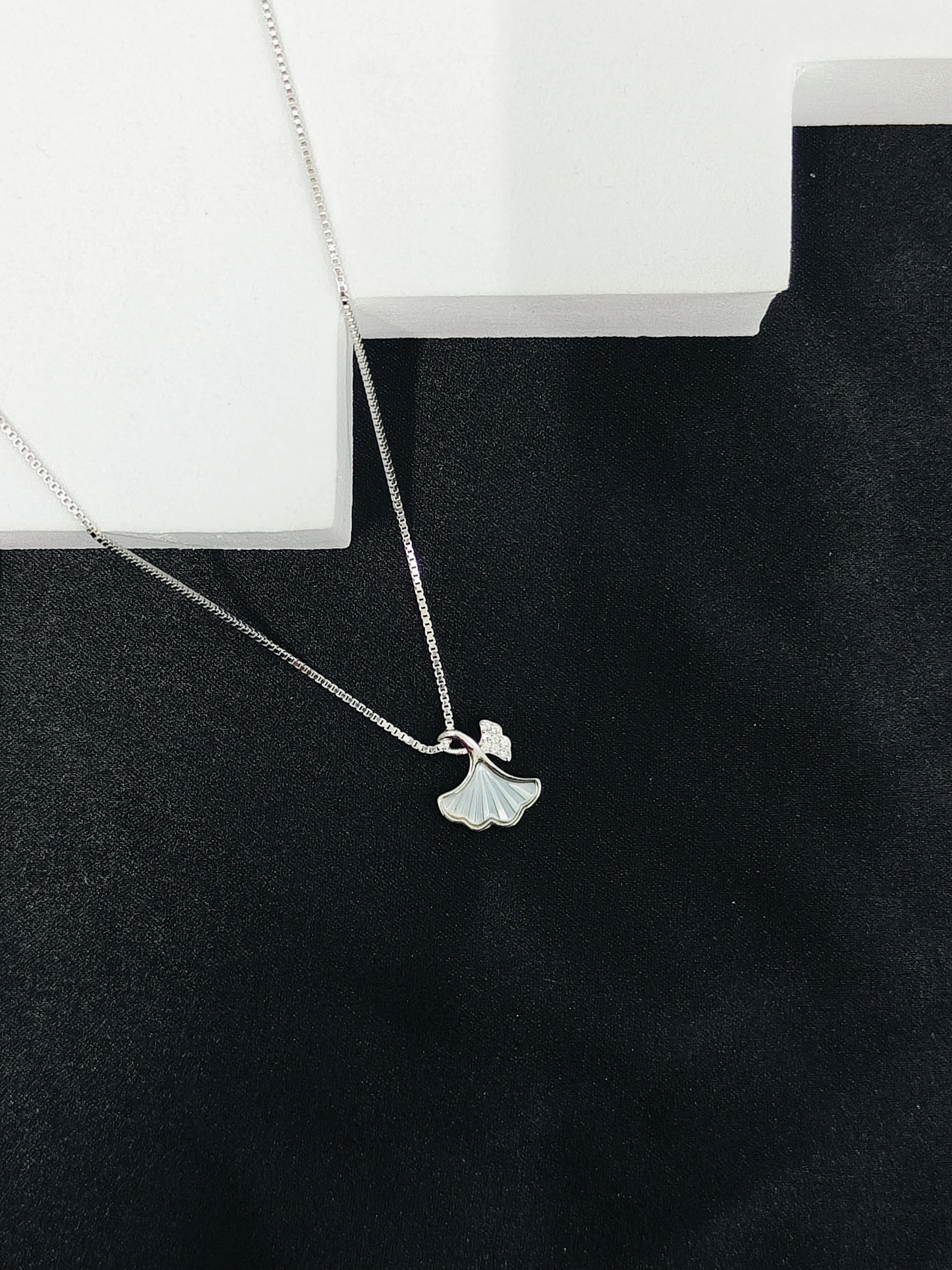 Silver necklace with a pendant on a black surface