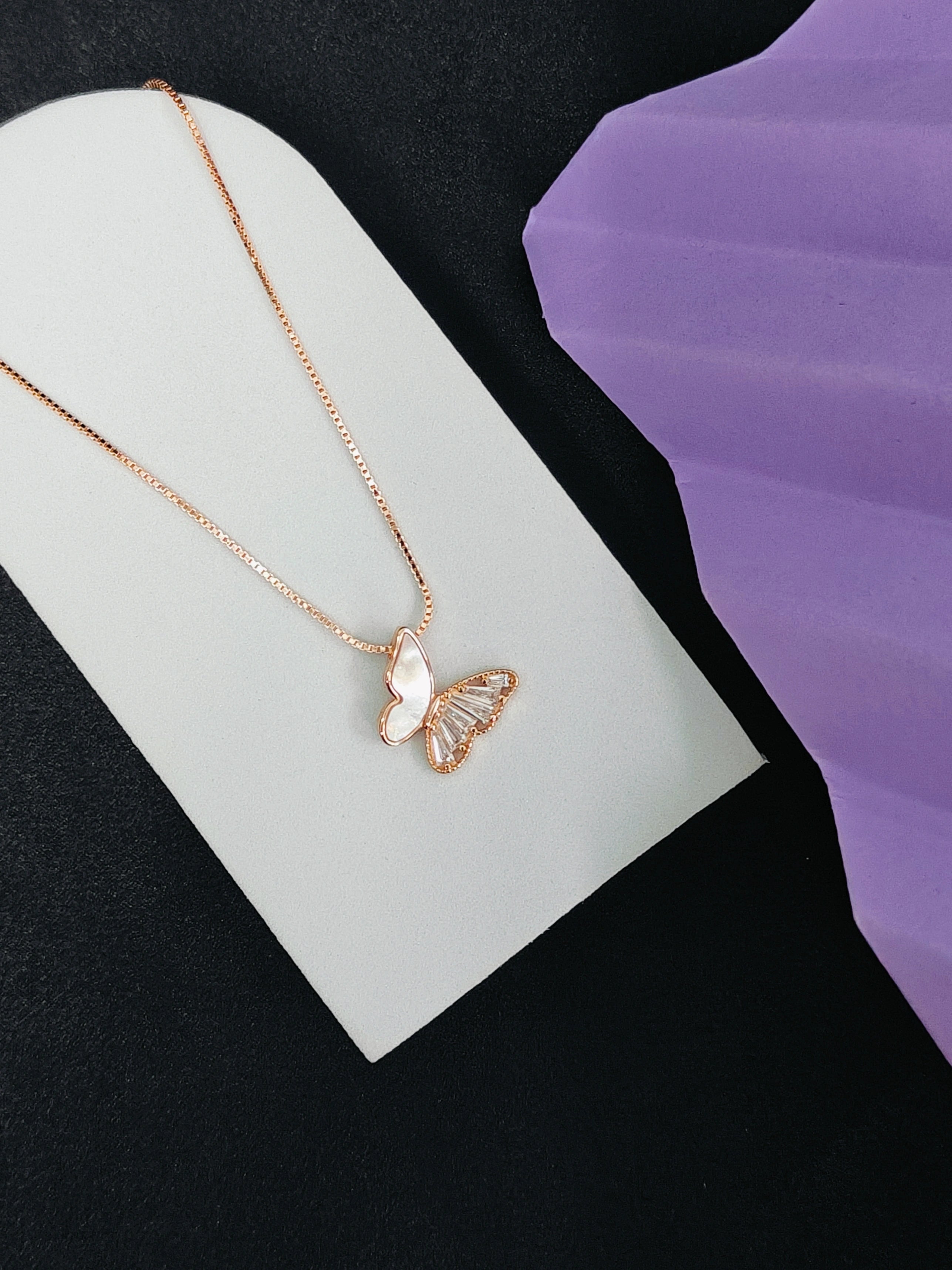 Butterfly necklace on a white card with a purple background