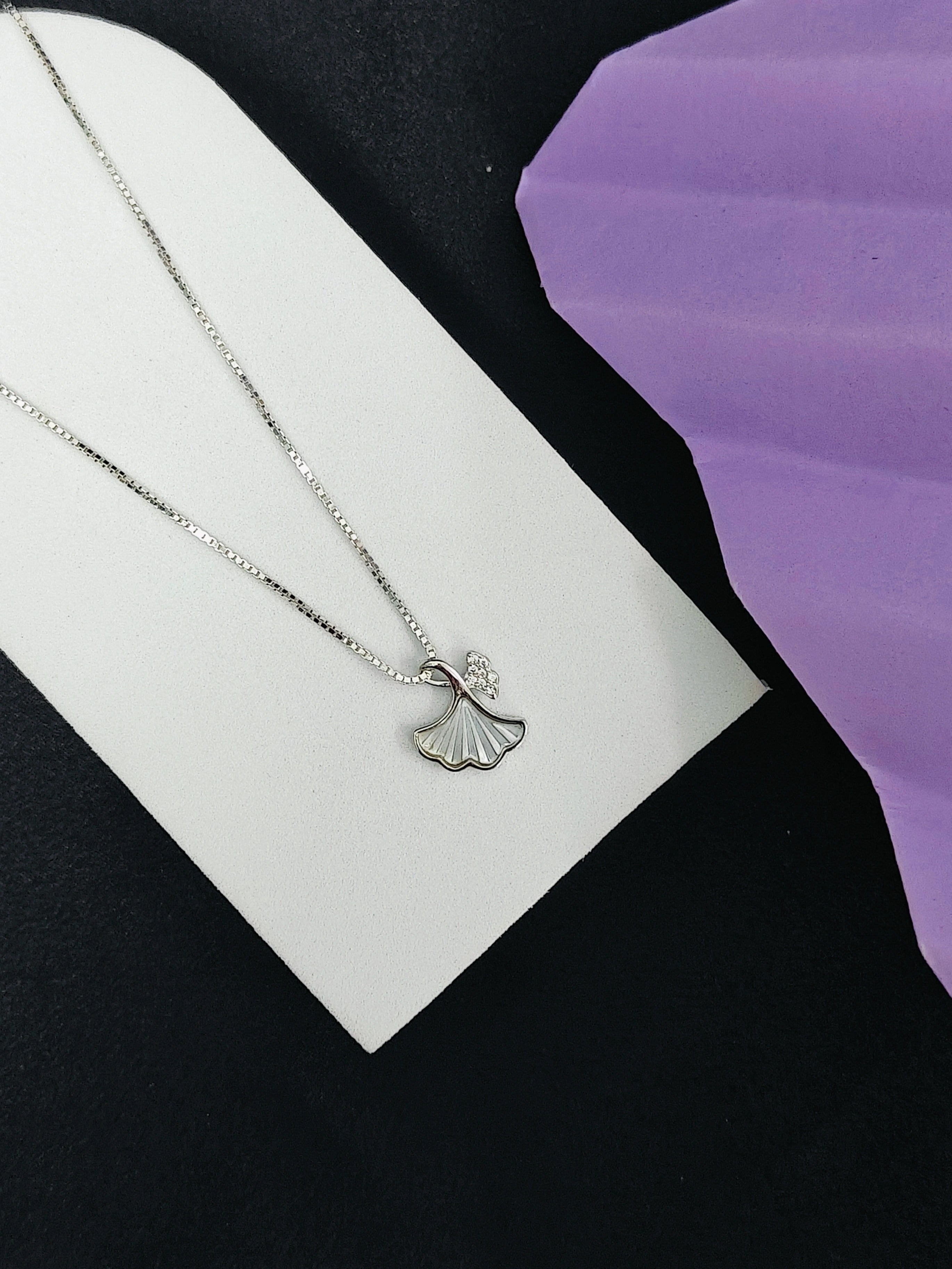 Silver necklace with a pendant on a black and white background