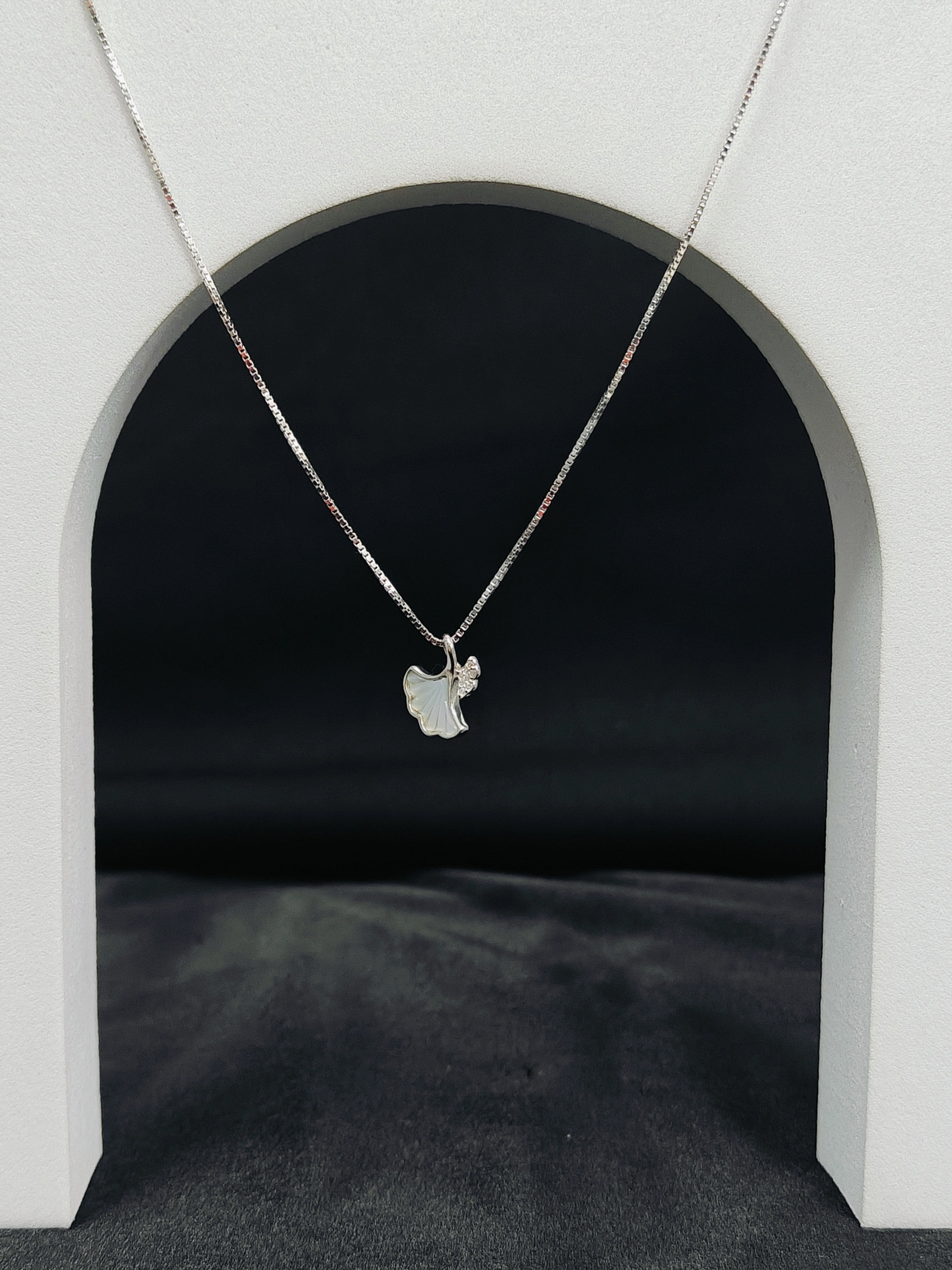 Silver necklace with a heart-shaped pendant on a dark background
