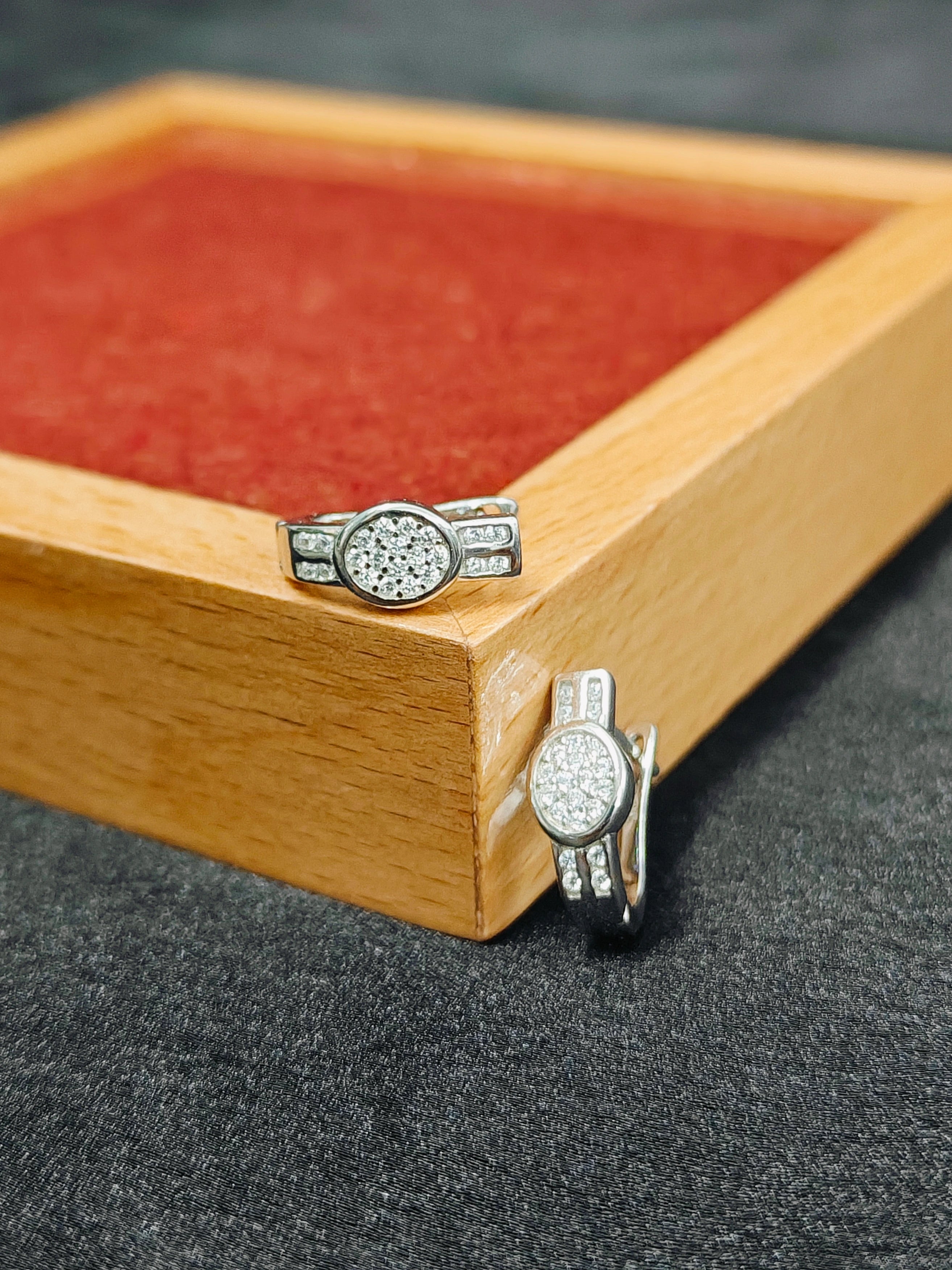 Silver ring with gemstones on a wooden box