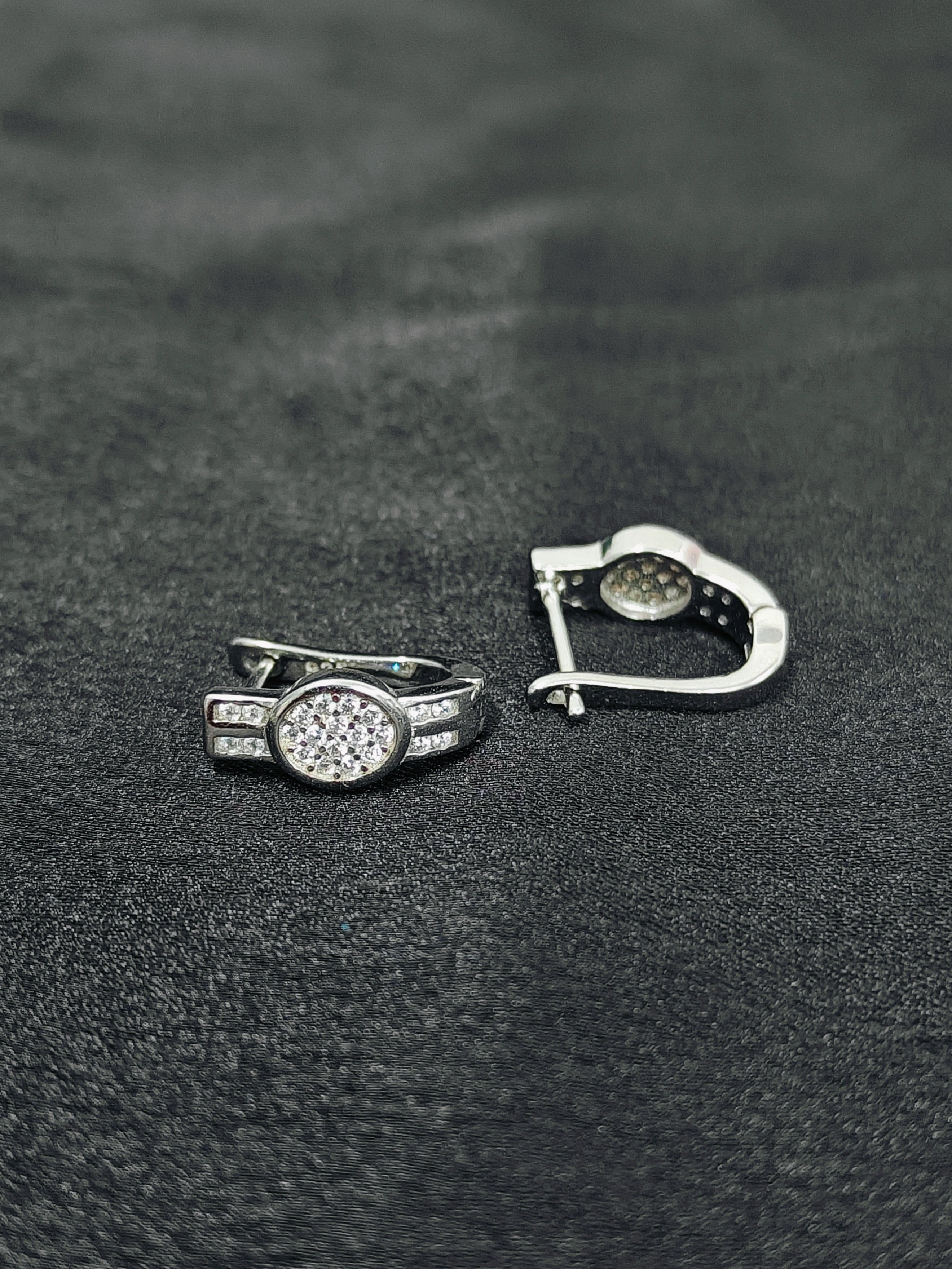 Silver ring with a diamond on a black textured surface
