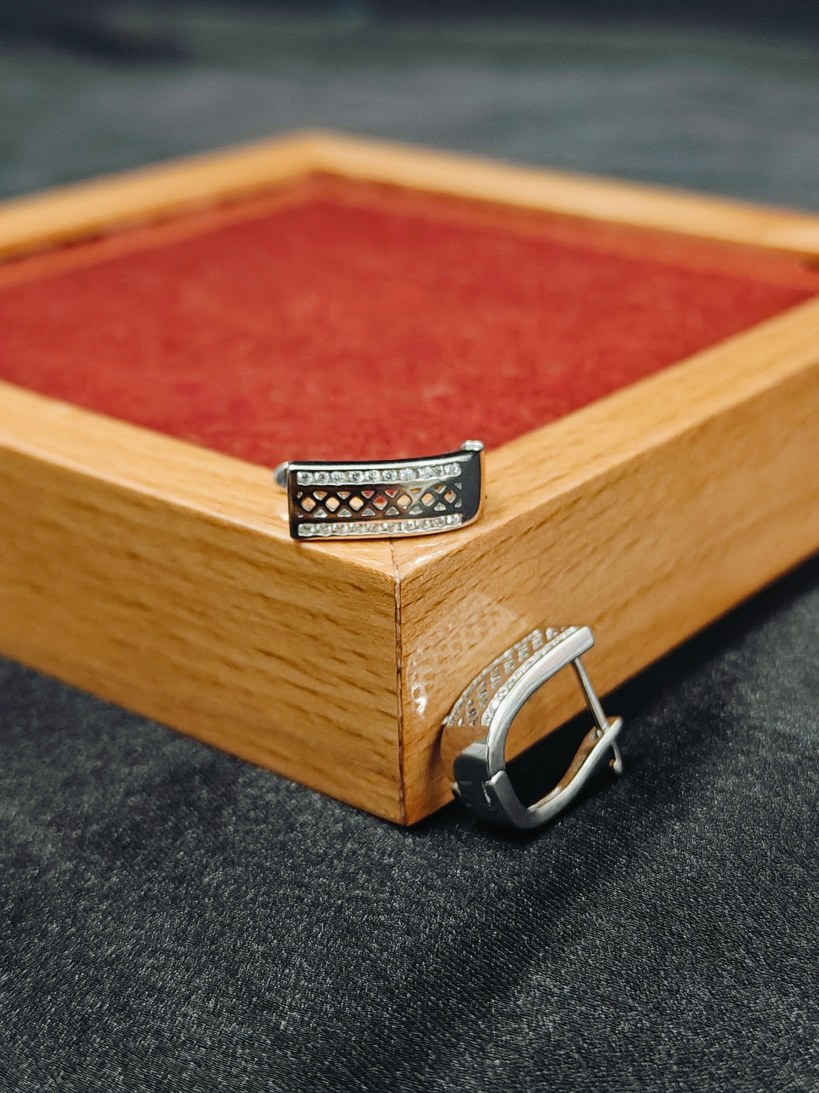 Silver buckle on a wooden box with red interior