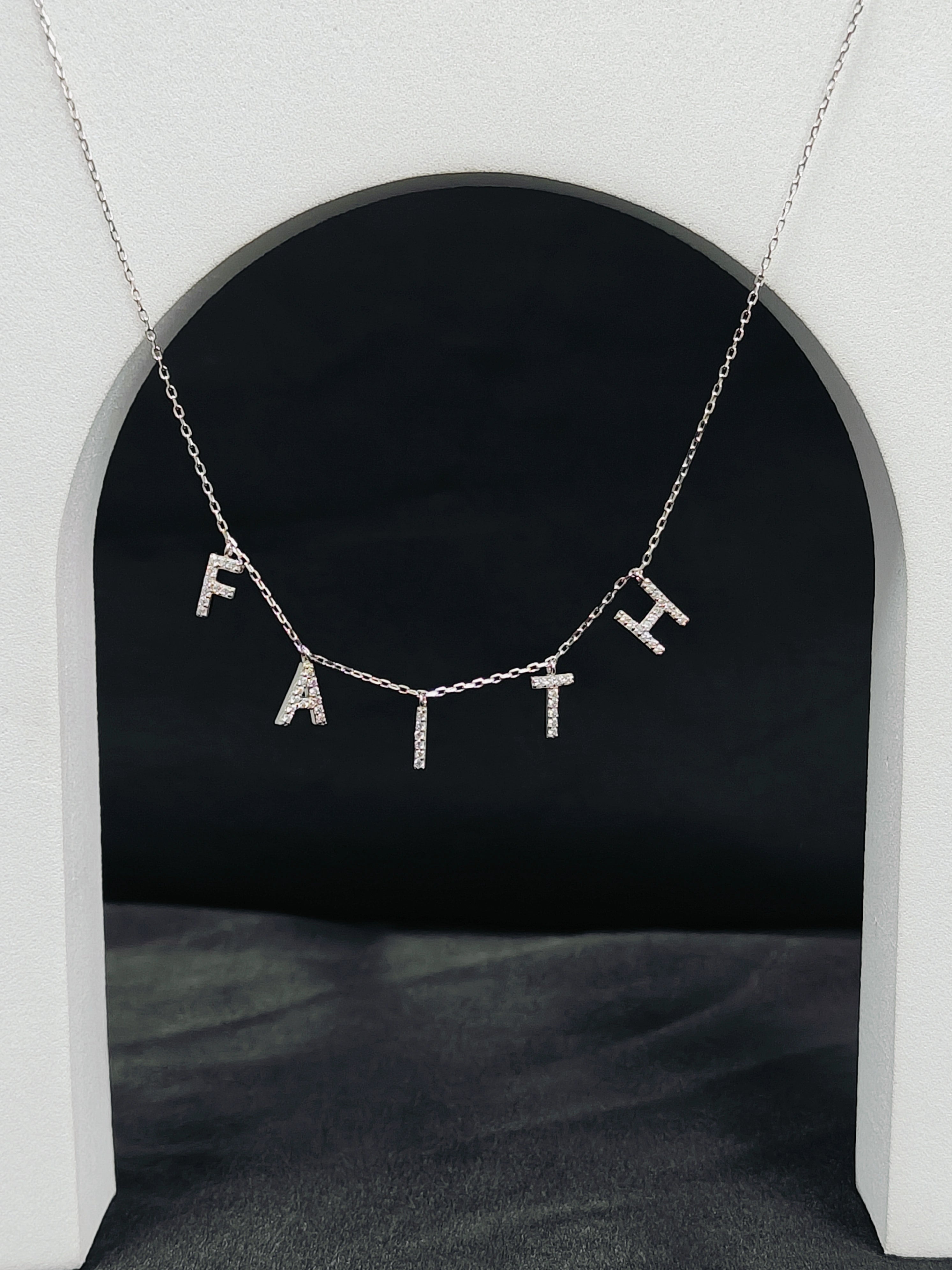 Necklace with 'FAITH' pendant on a dark background
