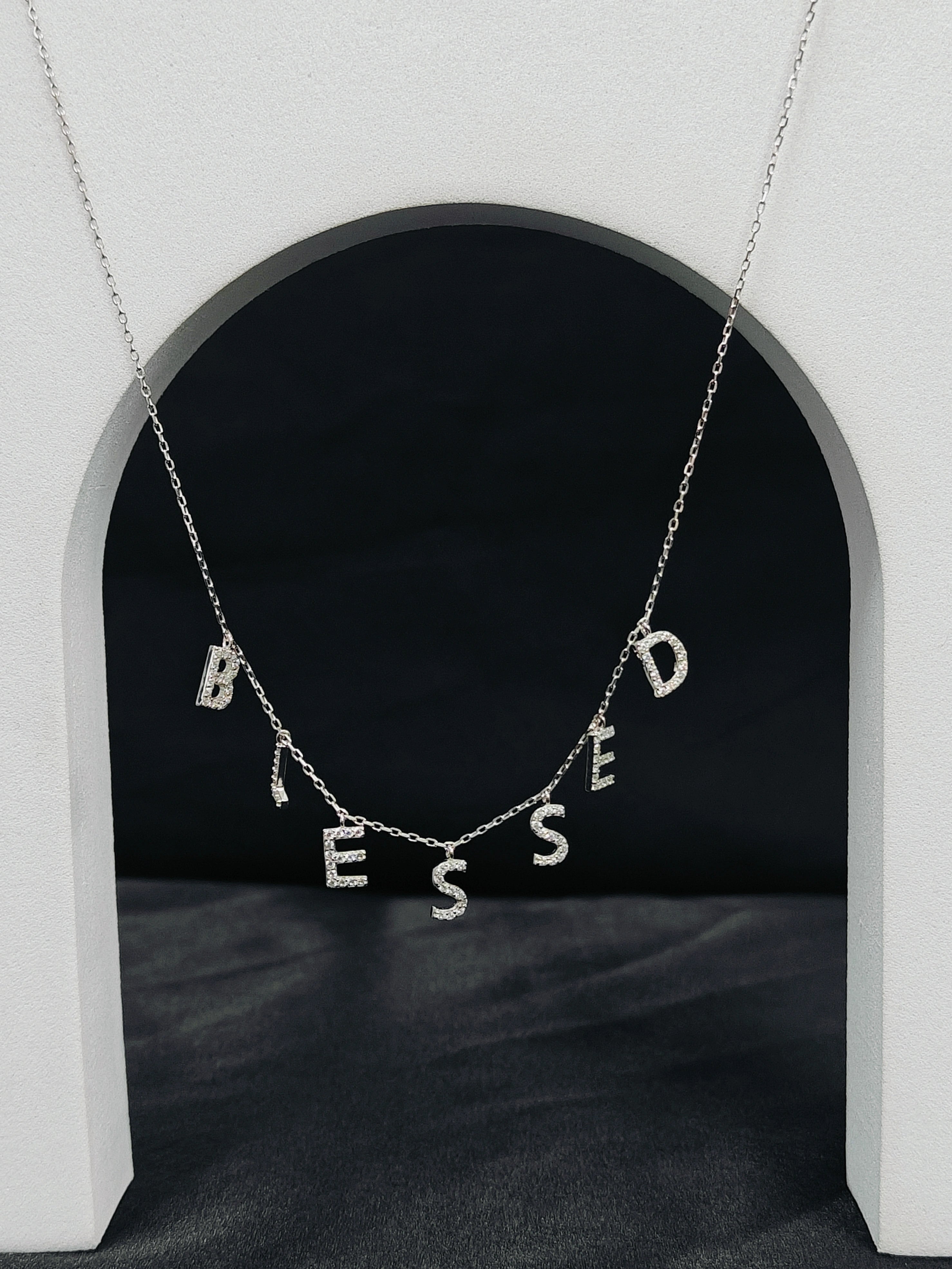Necklace with 'Blessed' pendant on a dark background