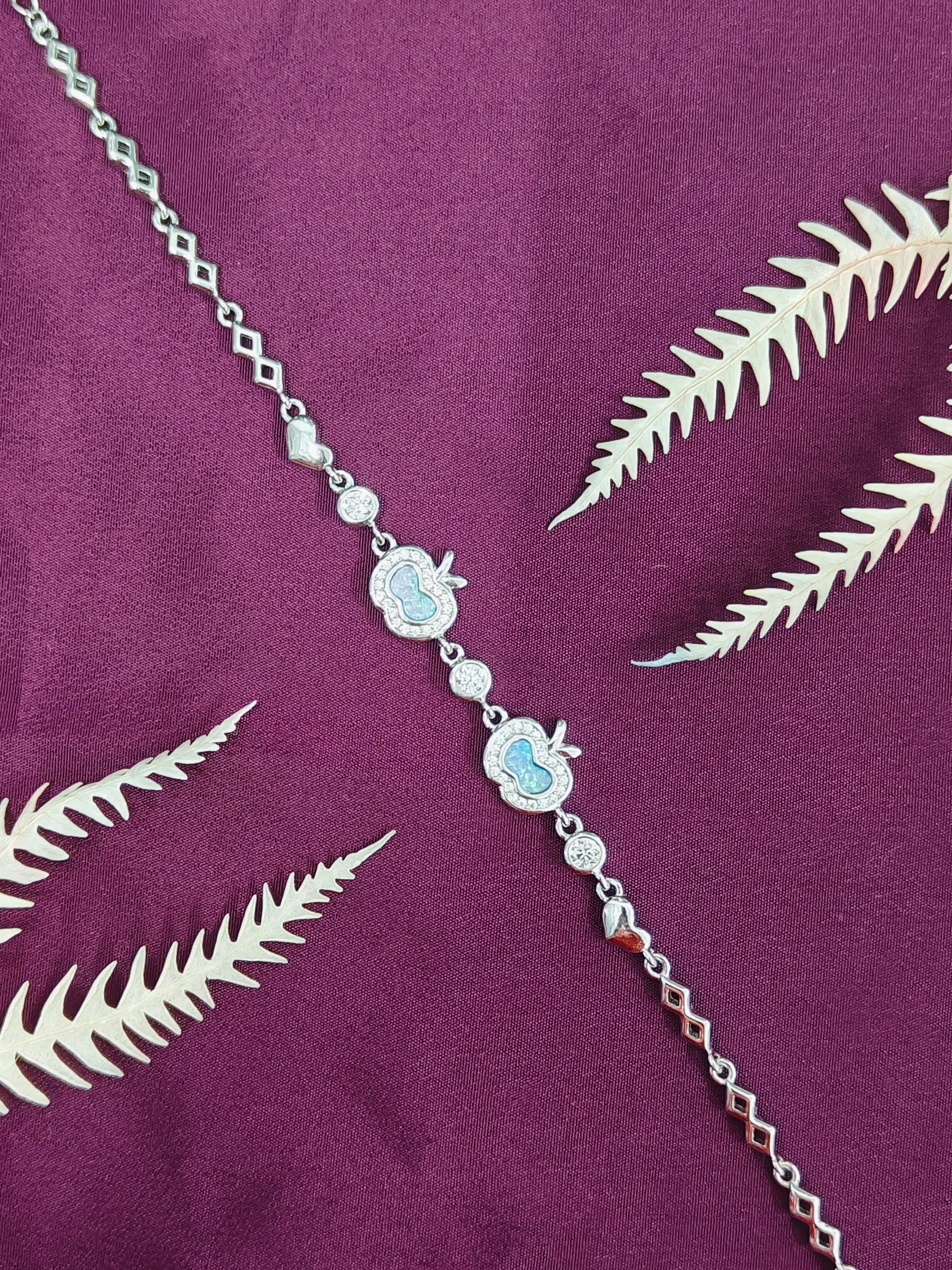 Silver necklace with blue stones on a purple fabric background