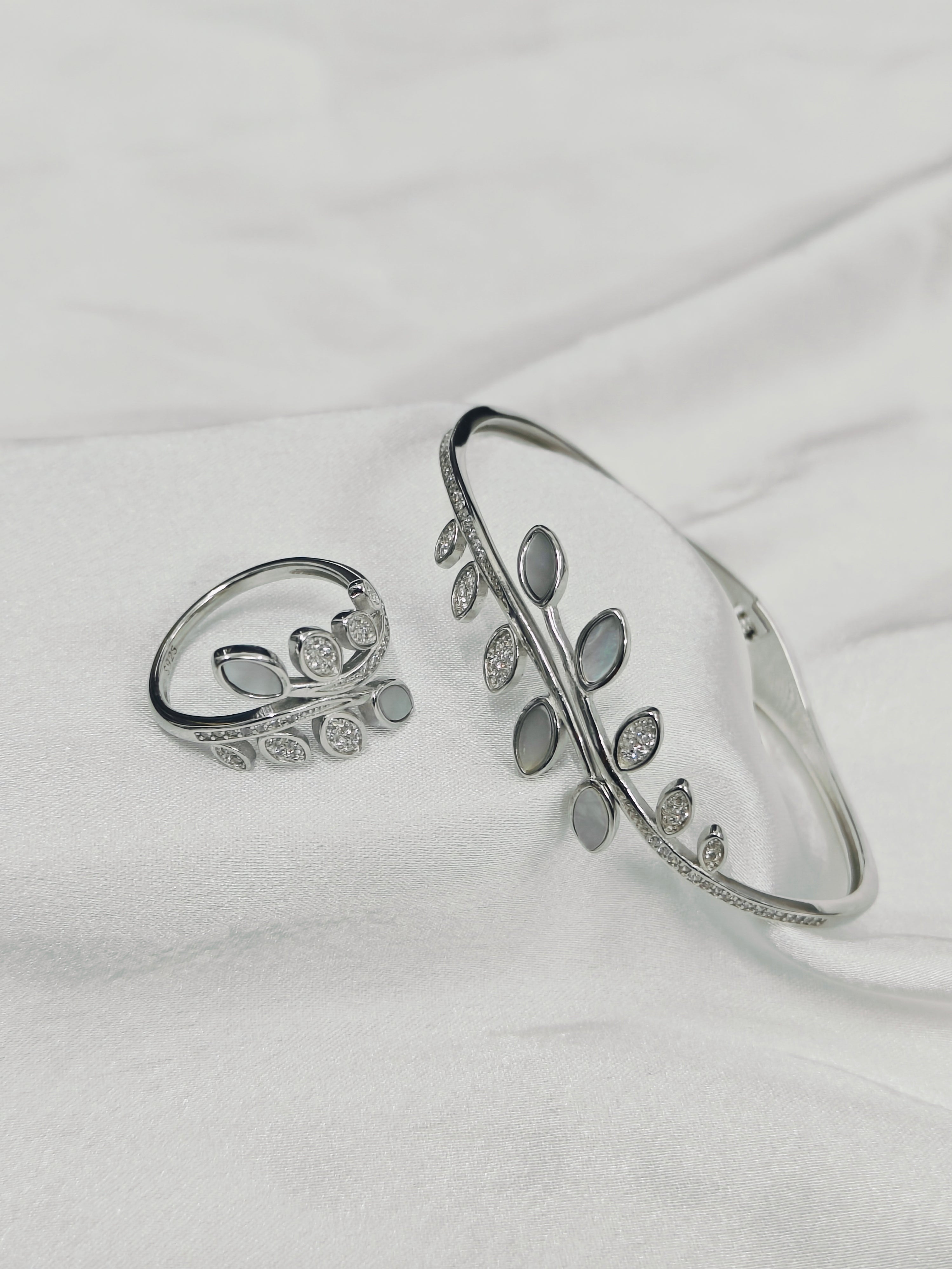 Silver bracelet and ring on a white fabric background