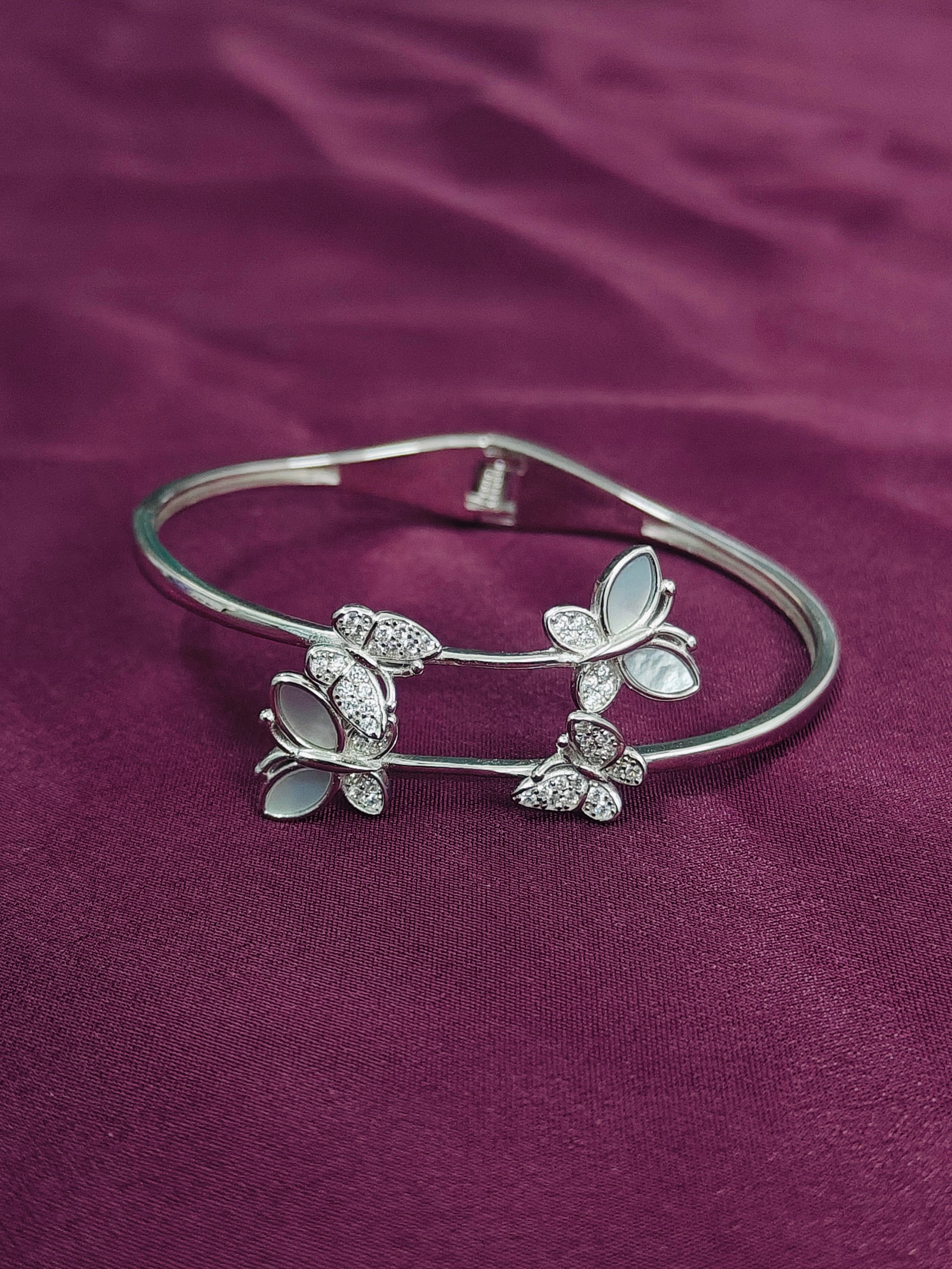 Silver butterfly bracelet on a purple fabric background
