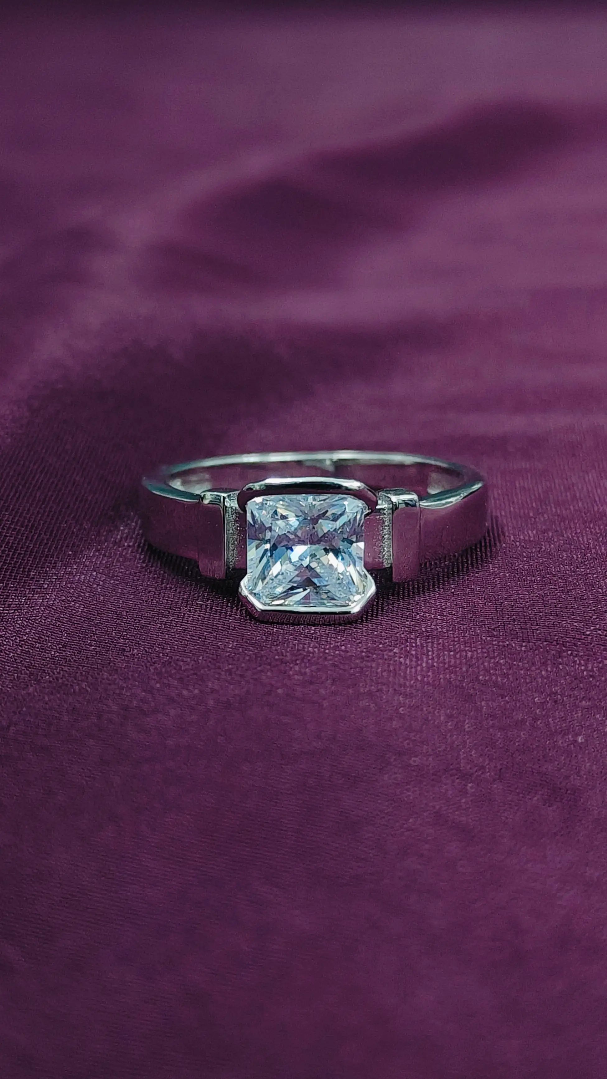 Diamond ring on a purple fabric background