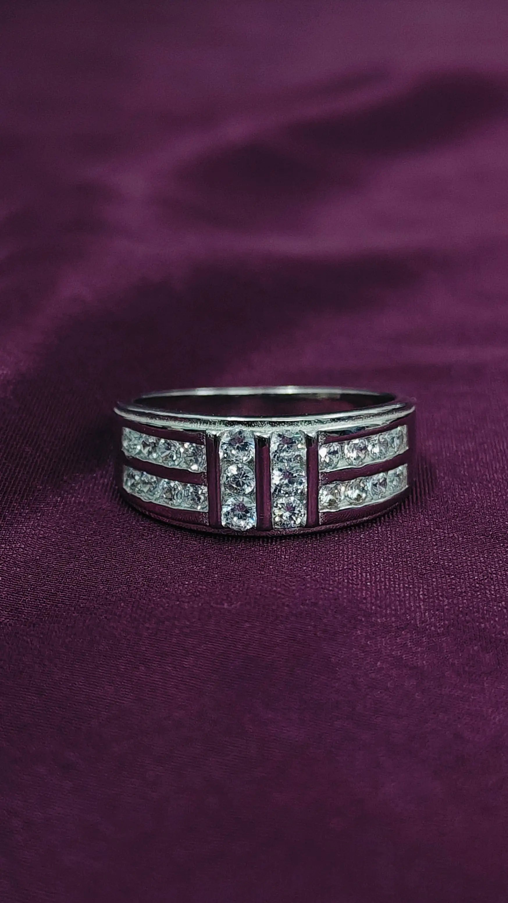 Silver ring with gemstones on a purple fabric background