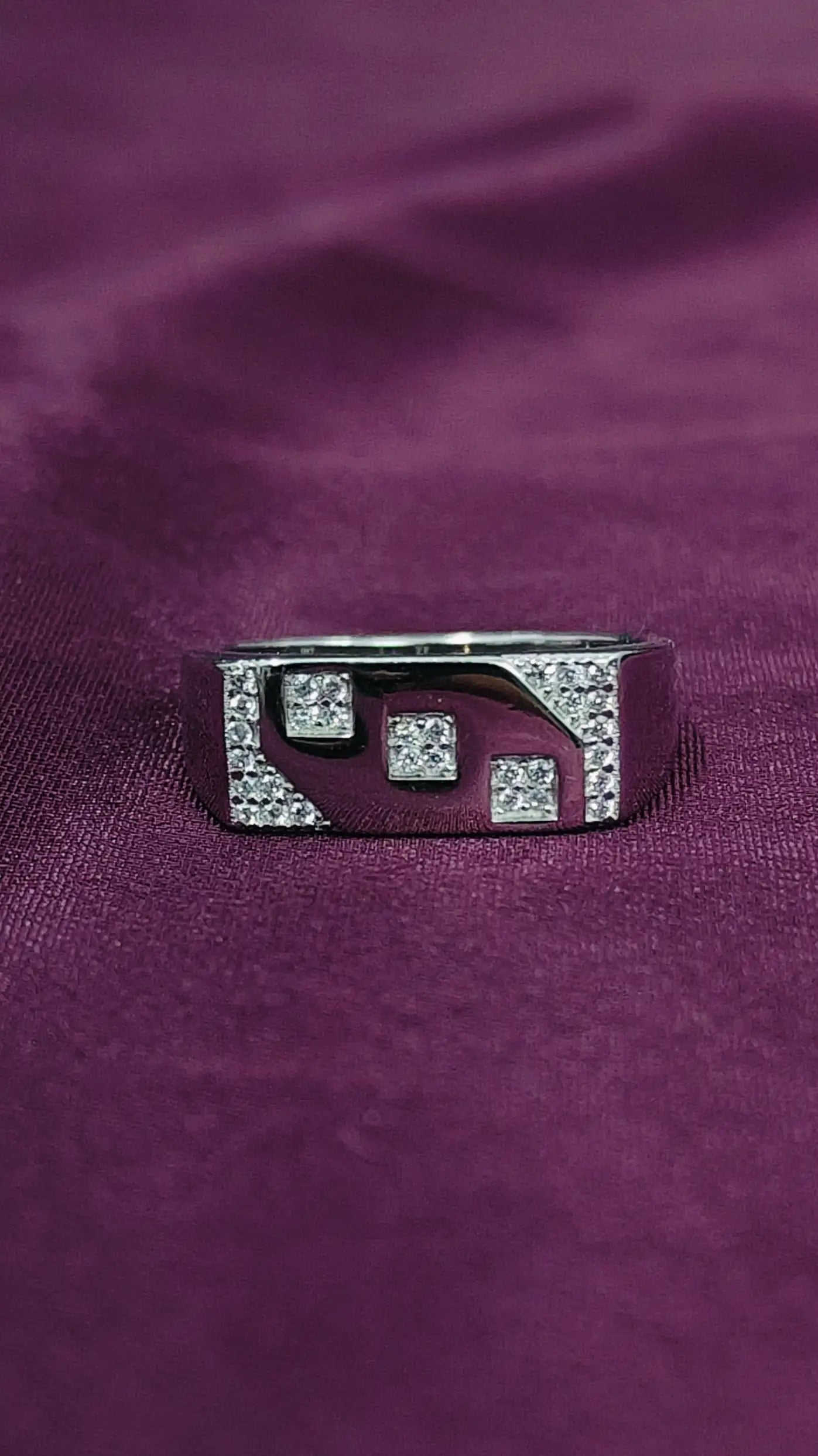 Silver ring with gemstones on a purple fabric background