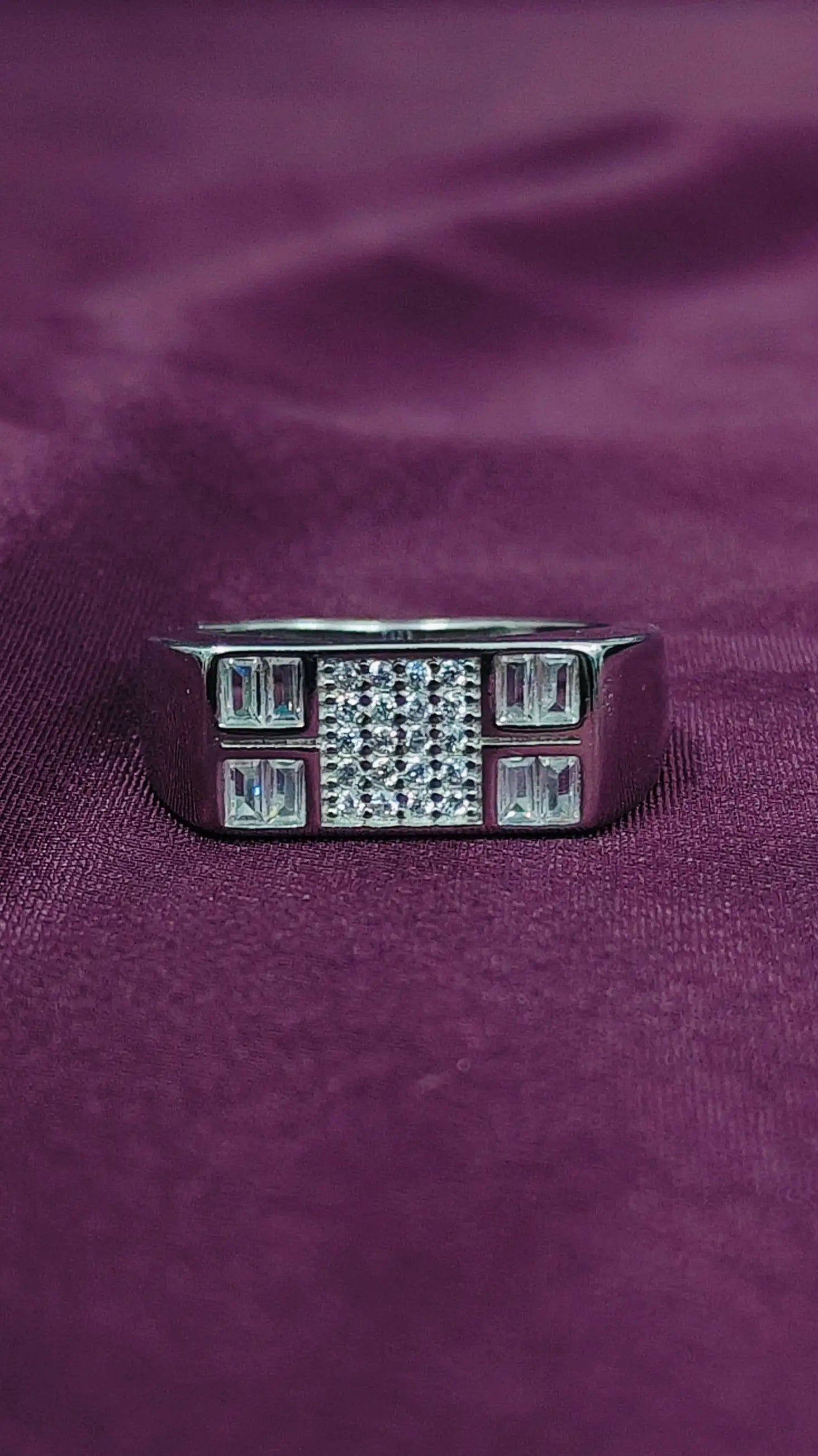 Silver ring with gemstones on a purple fabric background